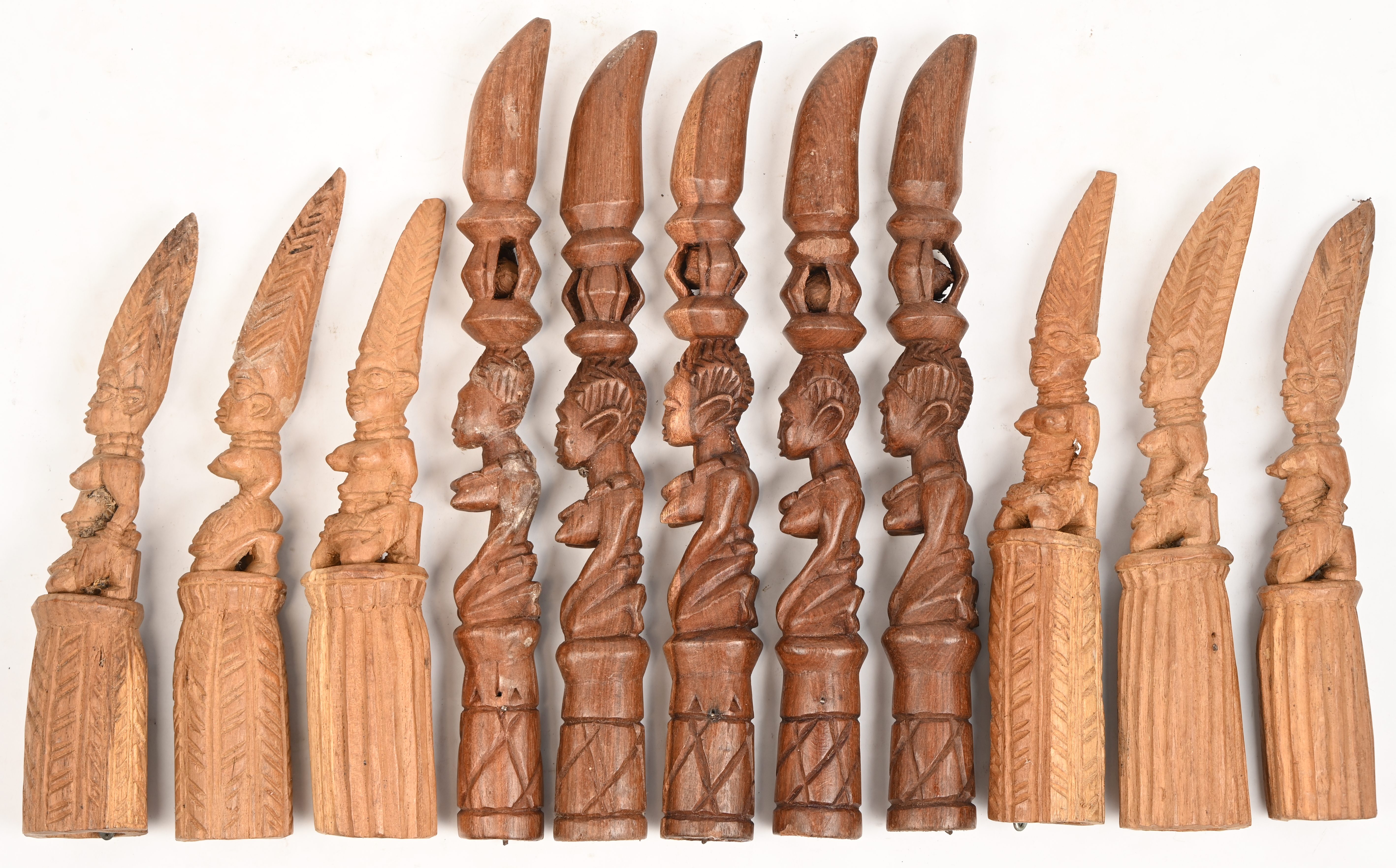 Een partij houten belletjes/rammelaars, in de vorm van vrouwen met een hoog kapsel of een kruik op het hoofd Een partij houten belletjes/rammelaars, in de vorm van vrouwen met een hoog kapsel of een kruik op het hoofd.