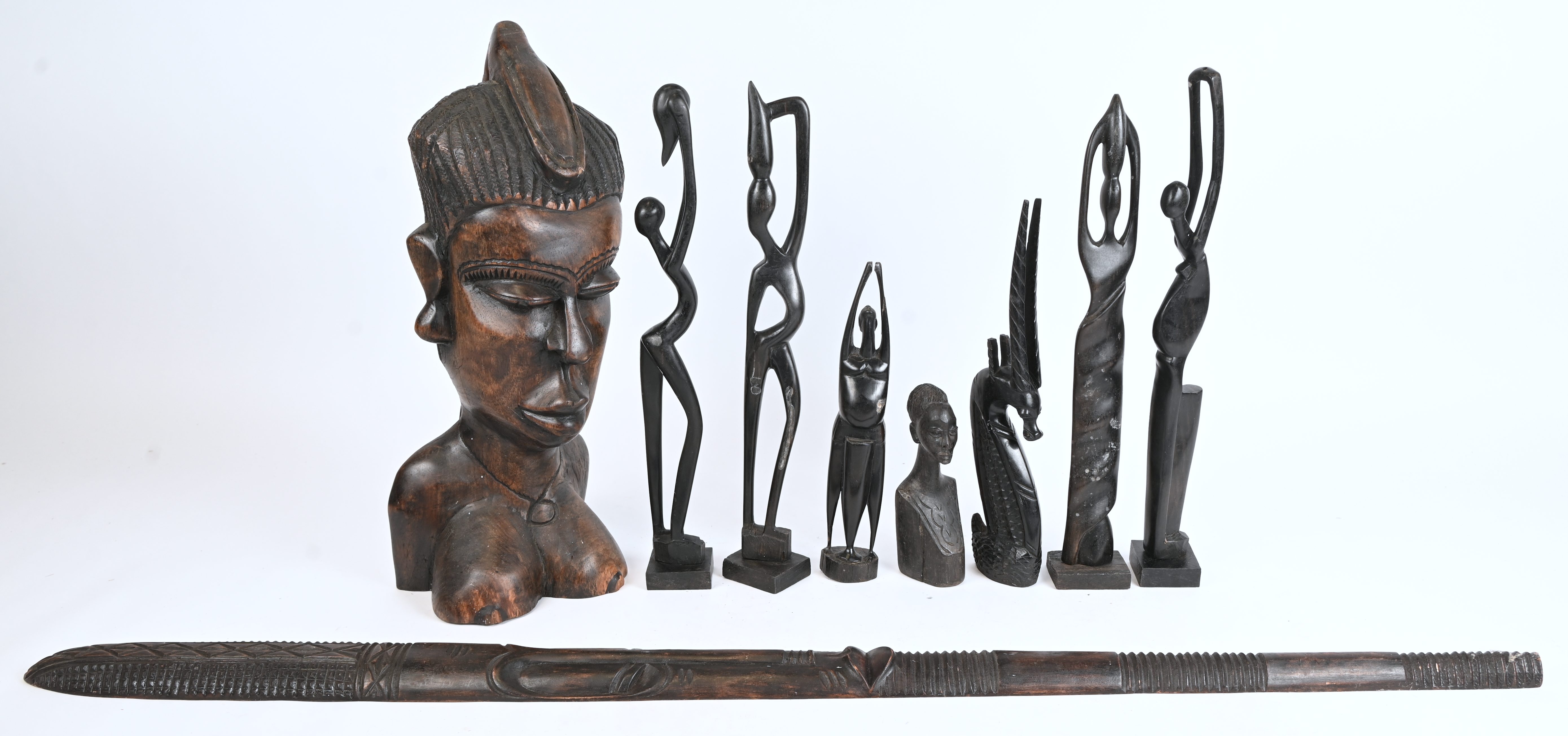 Een lot Afrikaanse houten beeldjes, mogelijk enkele van ebbenhout. Toegevoegd een langwerpig decoratief masker Een lot Afrikaanse houten beeldjes, mogelijk enkele van ebbenhout. Toegevoegd een langwerpig decoratief masker.