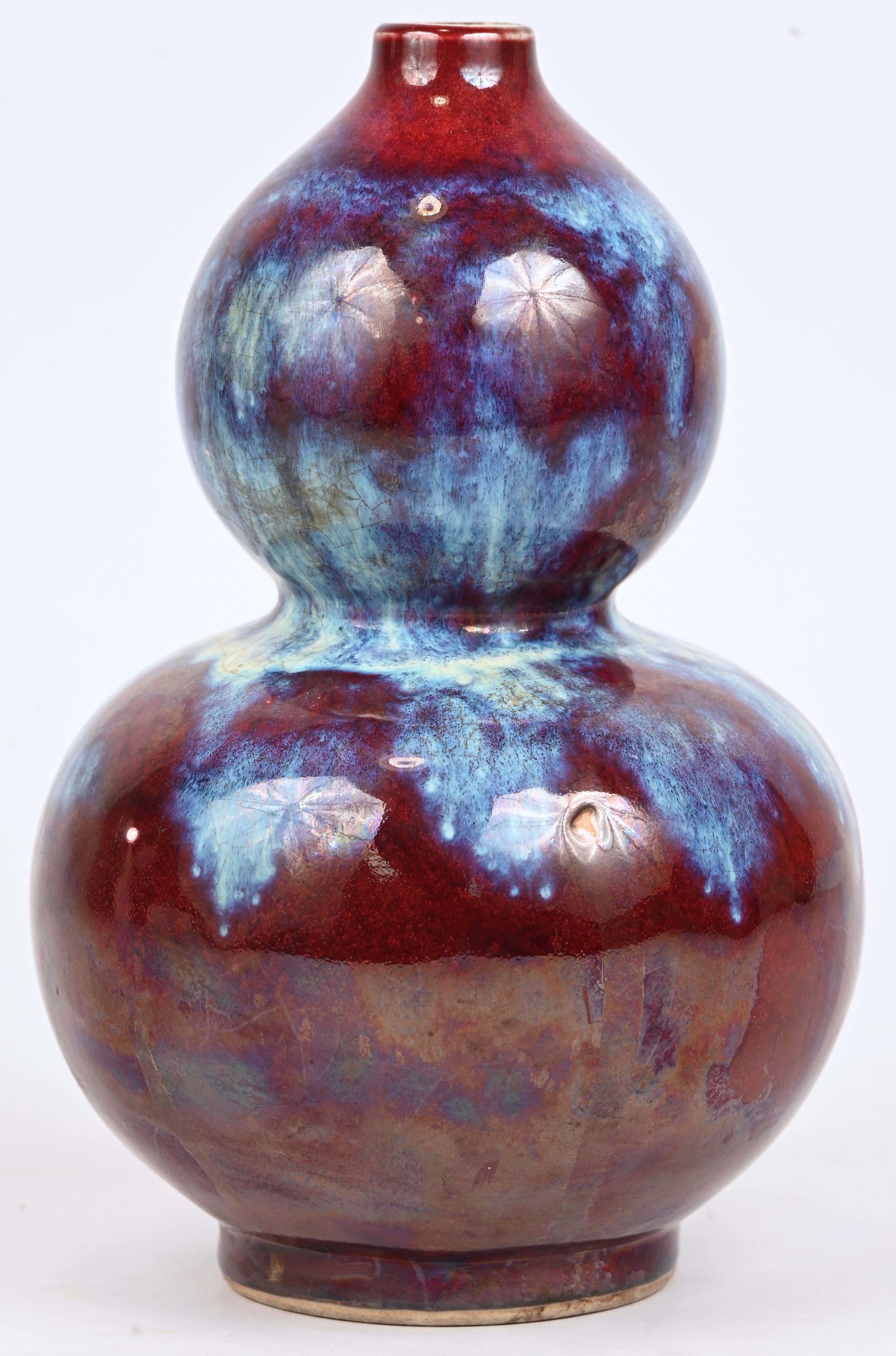 Een kalebas vaas met flambé glazuur. In de stijl van de Yongzheng-periode. Draagt onderaan een stempel Een kalebas vaas met flambé glazuur. In de stijl van de Yongzheng-periode. Draagt onderaan een stempel.