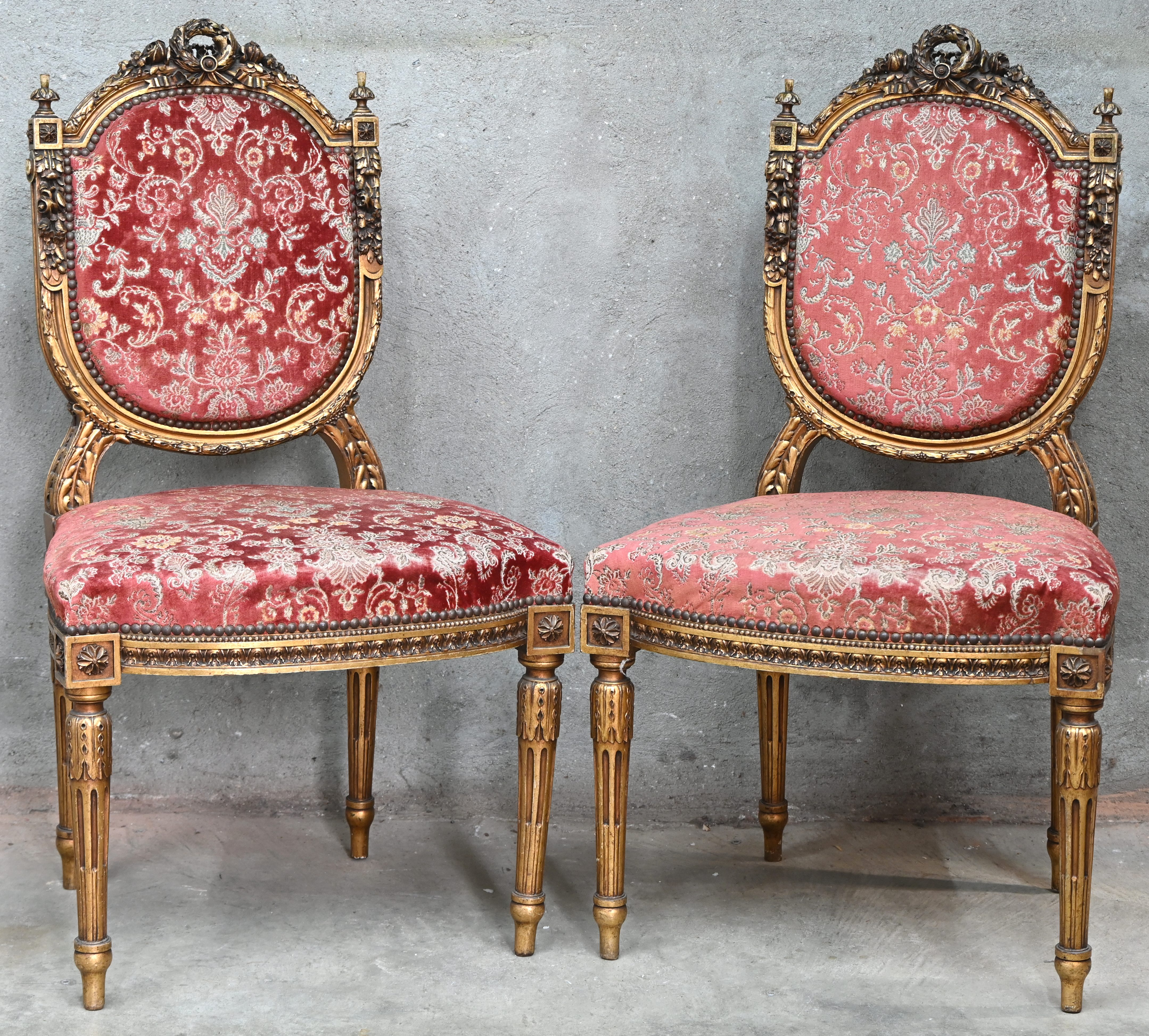Twee stoelen in Louis XVI stijl. Van goudkleurig gesculpteerd hout met fluwelen bekleding Twee stoelen in Louis XVI stijl. Van goudkleurig gesculpteerd hout met fluwelen bekleding.