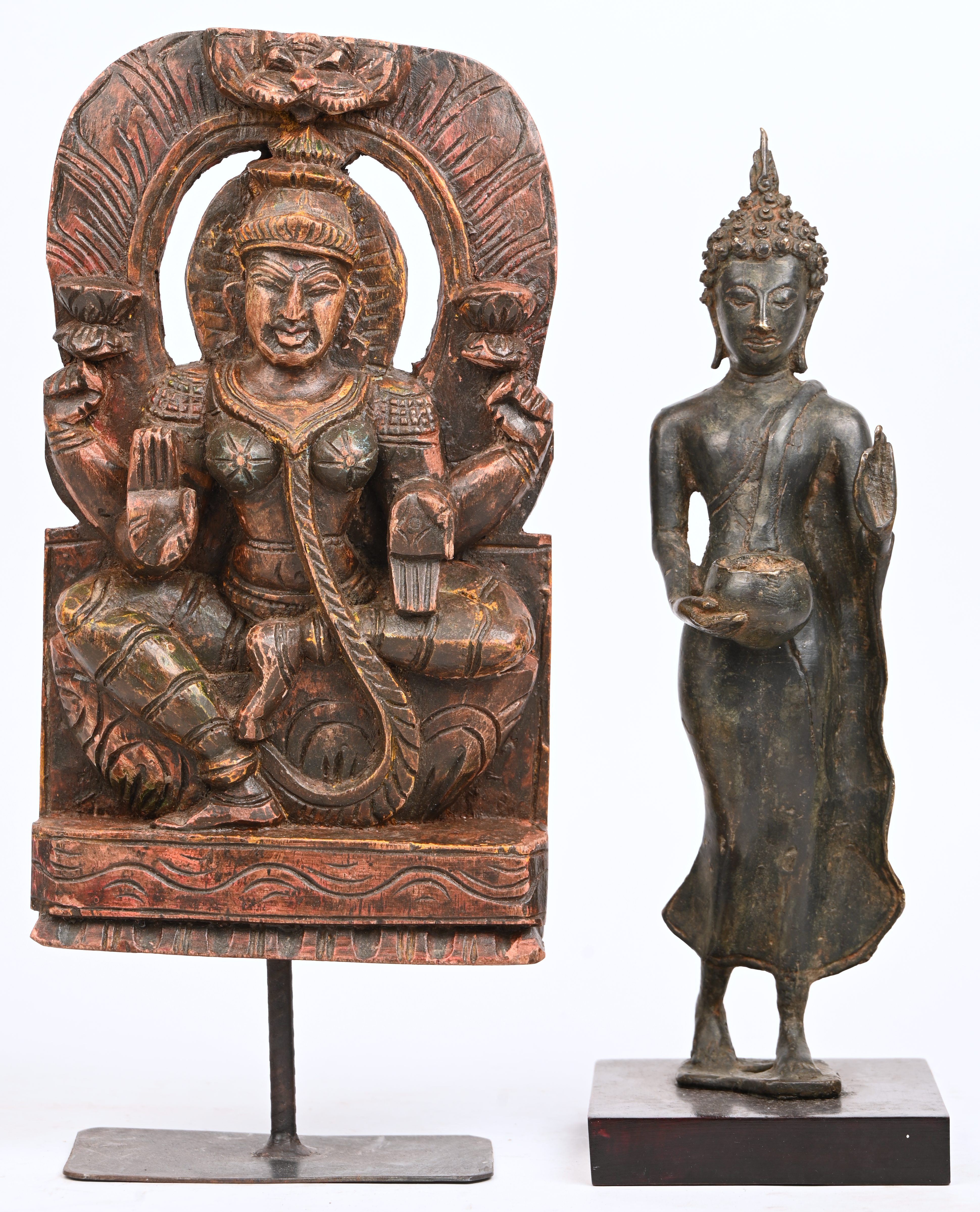 Twee Aziatische beeldjes. Een Thaise medicijn Boeddha van gepatineerd brons. Godin Lakshmi, van gesculpteerd hout met resten van polychrome beschildering Twee Aziatische beeldjes. Een Thaise medicijn Boeddha van gepatineerd brons. Godin Lakshmi, van gesculpteerd hout met resten van polychrome beschildering.