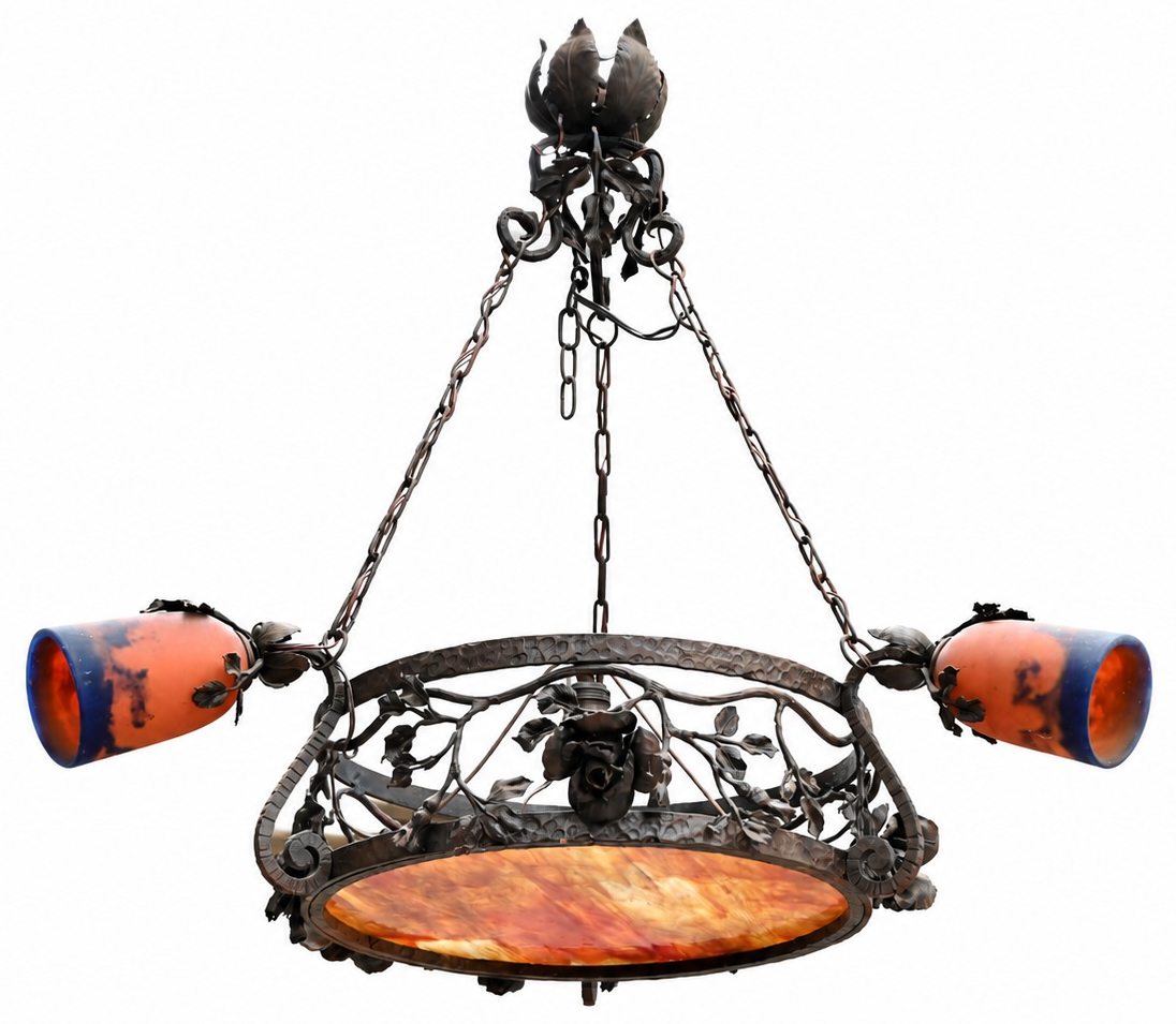 Een smeedijzeren luchter met rozen versierd, centraal lichtpunt en drie armen met kapjes in de stijl van Galé. Gesigneerd op de plafondhaak Een smeedijzeren luchter met rozen versierd, centraal lichtpunt en drie armen met kapjes in de stijl van Galé. Gesigneerd op de plafondhaak.