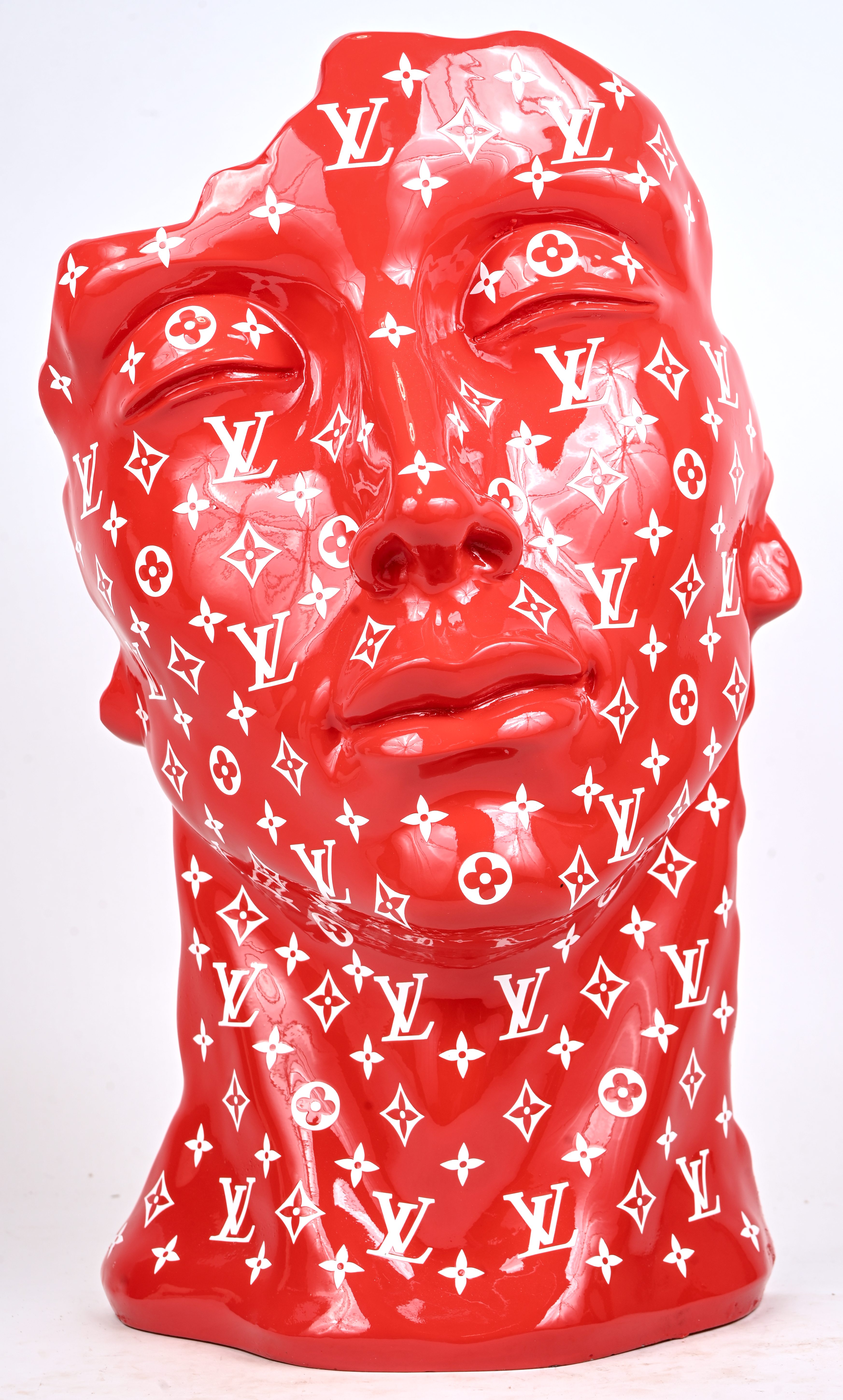 ‘Dromend’. Een buste van een jonge man met uitgehouwen effect aan de zij-en achterkant. In rood kunststof met het logo van Louis Vuitton bedrukt ‘Dromend’. Een buste van een jonge man met uitgehouwen effect aan de zij-en achterkant. In rood kunststof met het logo van Louis Vuitton bedrukt.