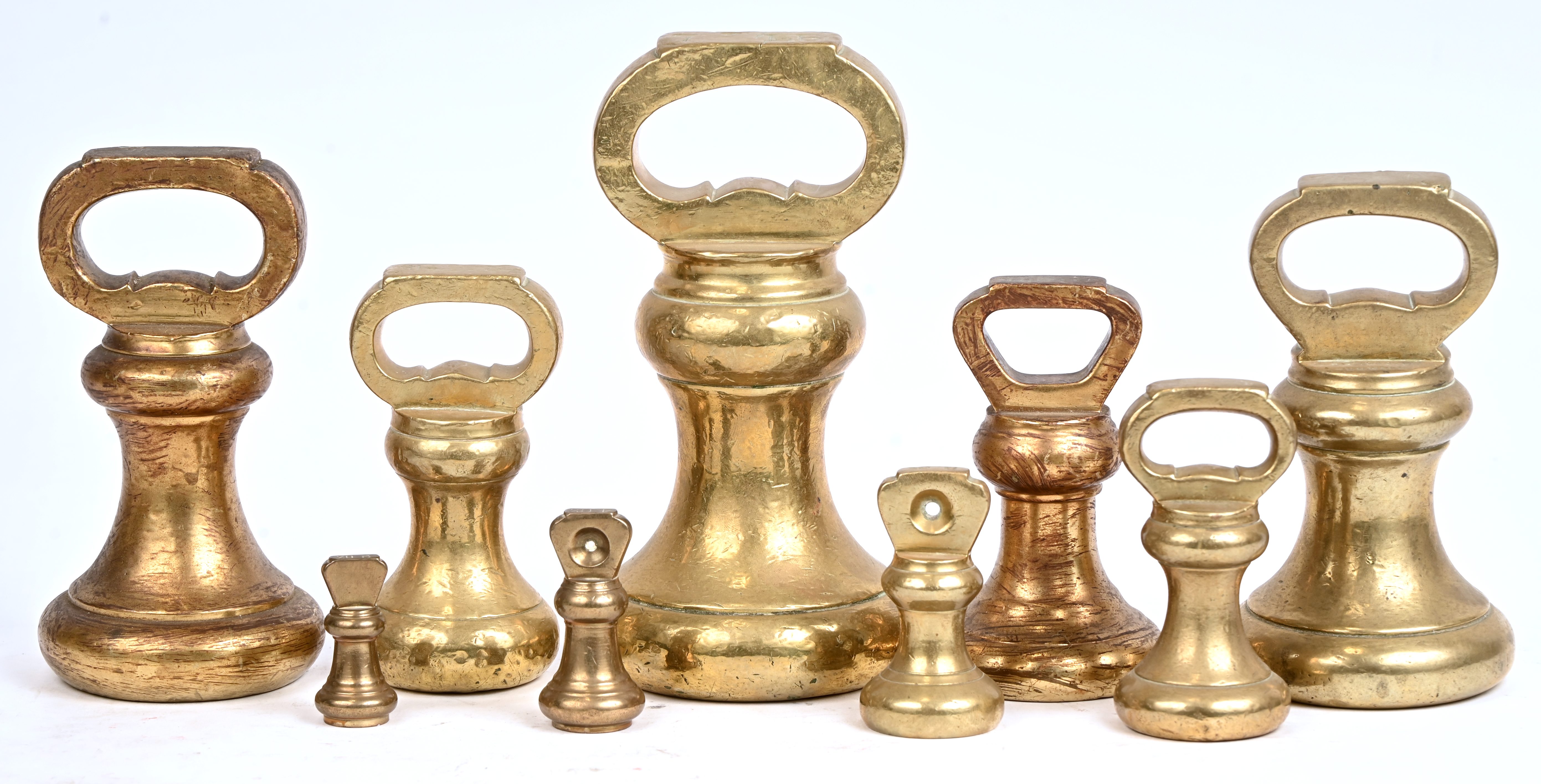 Een lot van 9 koperen gewichten (Bell weight), gebruikt op traditionele winkelweegschalen Een lot van 9 koperen gewichten (Bell weight), gebruikt op traditionele winkelweegschalen.