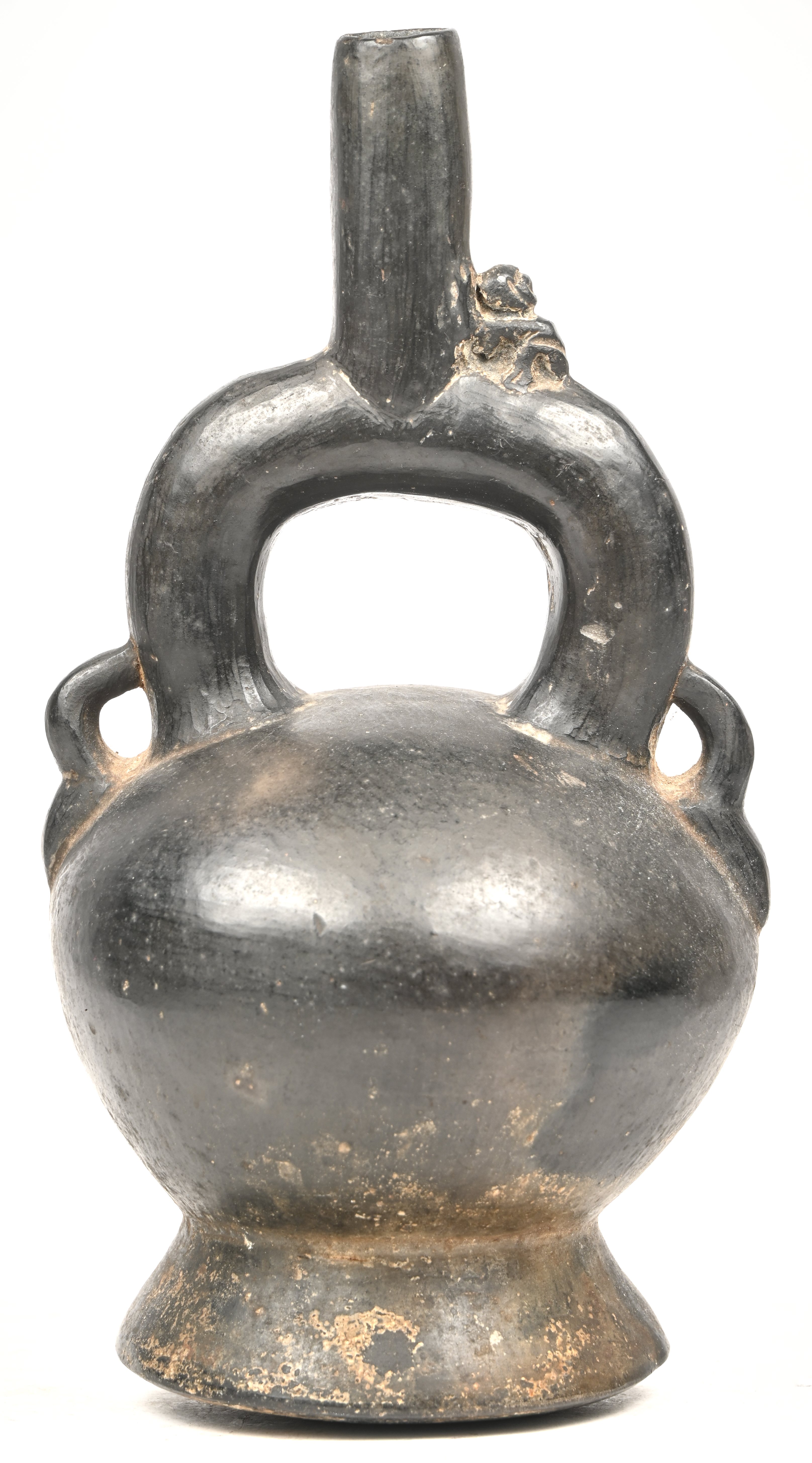 Een precolumbiaanse Chimu blackware keramieken stijgbeugel-tuitfles met gesculpteerd figuurtje van een aapje bovenaan. Peru Een precolumbiaanse Chimu blackware keramieken stijgbeugel-tuitfles met gesculpteerd figuurtje van een aapje bovenaan. Peru.