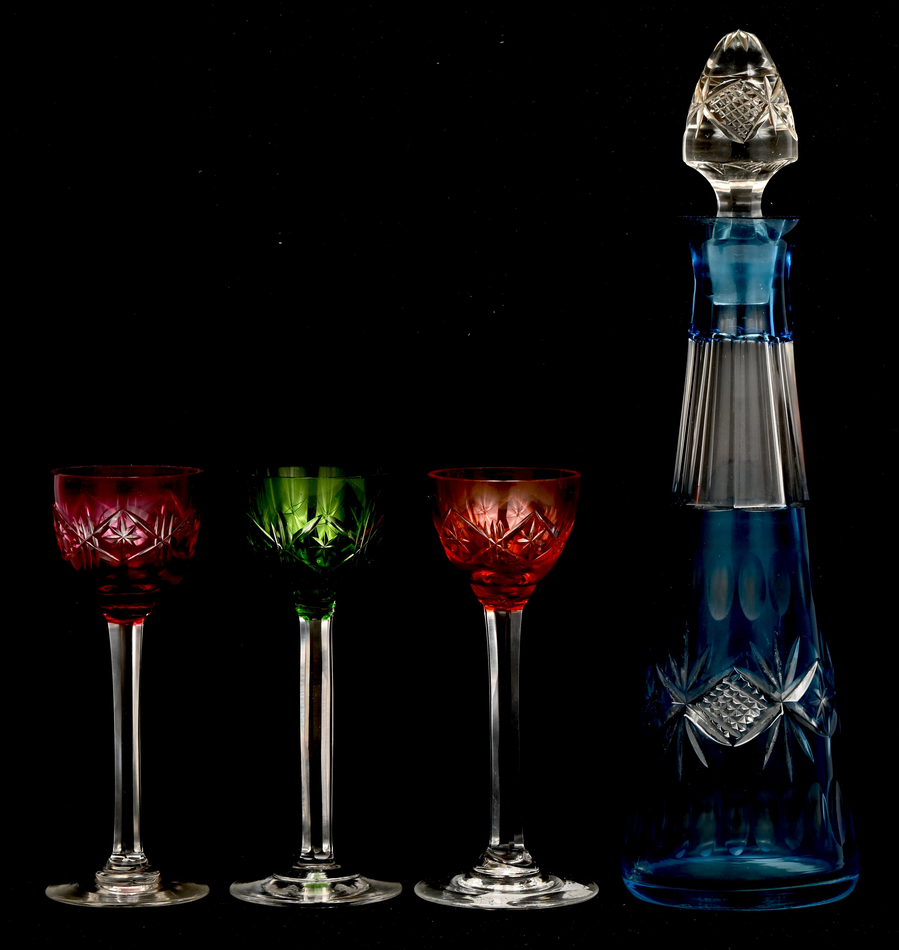 Een kristallen karaf met 3 borrelglaasjes, meerkleurig Een kristallen karaf met 3 borrelglaasjes, meerkleurig.
