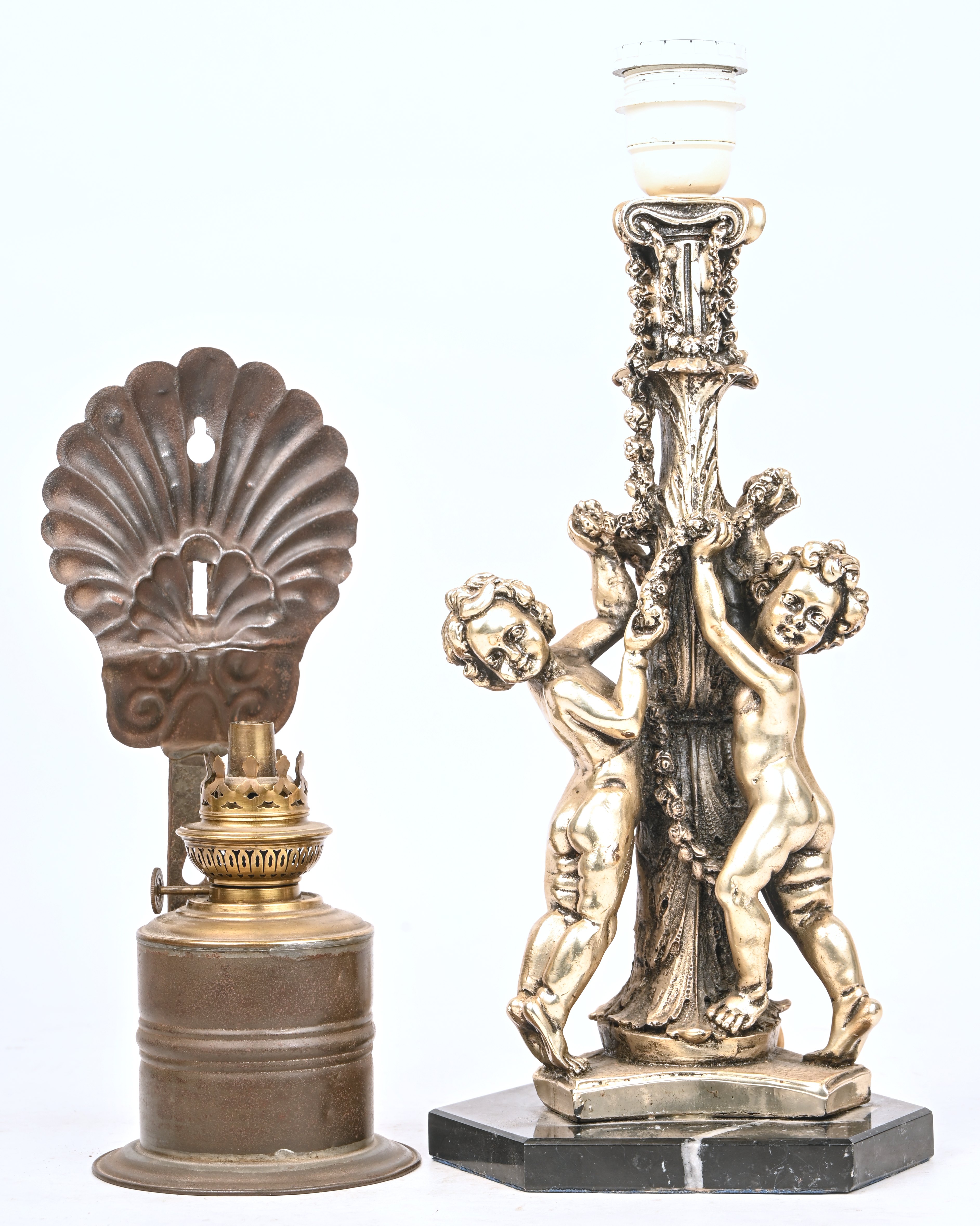 Een kunststoffen lampenvoet met 2 putti. Toegevoegd een omgebouwde koperen olielamp Een kunststoffen lampenvoet met 2 putti. Toegevoegd een omgebouwde koperen olielamp.