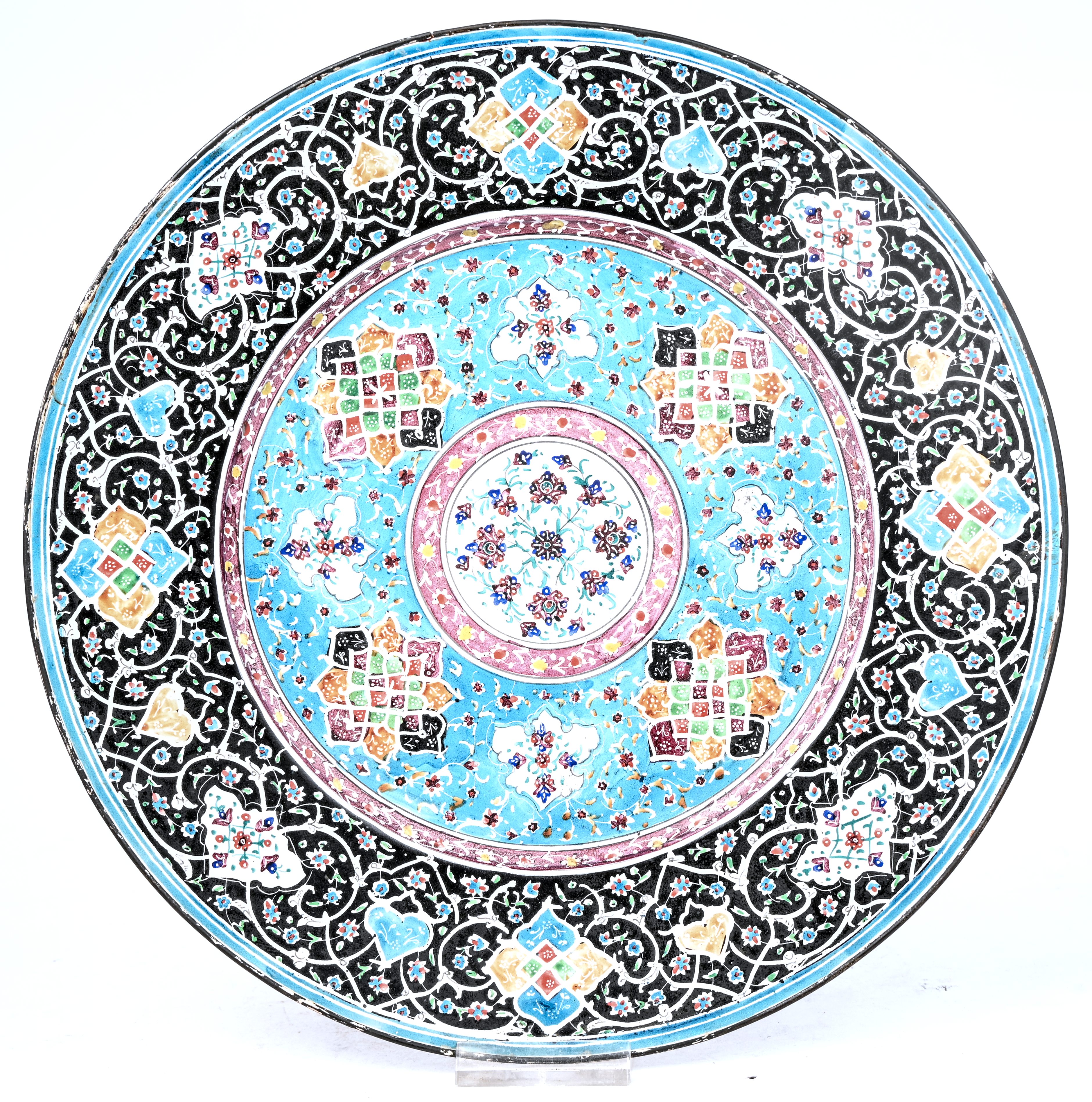Een Perzisch geëmailleerd metalen bord met geometrisch floraal decor. Vermoedelijk Minakari, Esfahan. Jaren 60 Een Perzisch geëmailleerd metalen bord met geometrisch floraal decor. Vermoedelijk Minakari, Esfahan. Jaren 60.