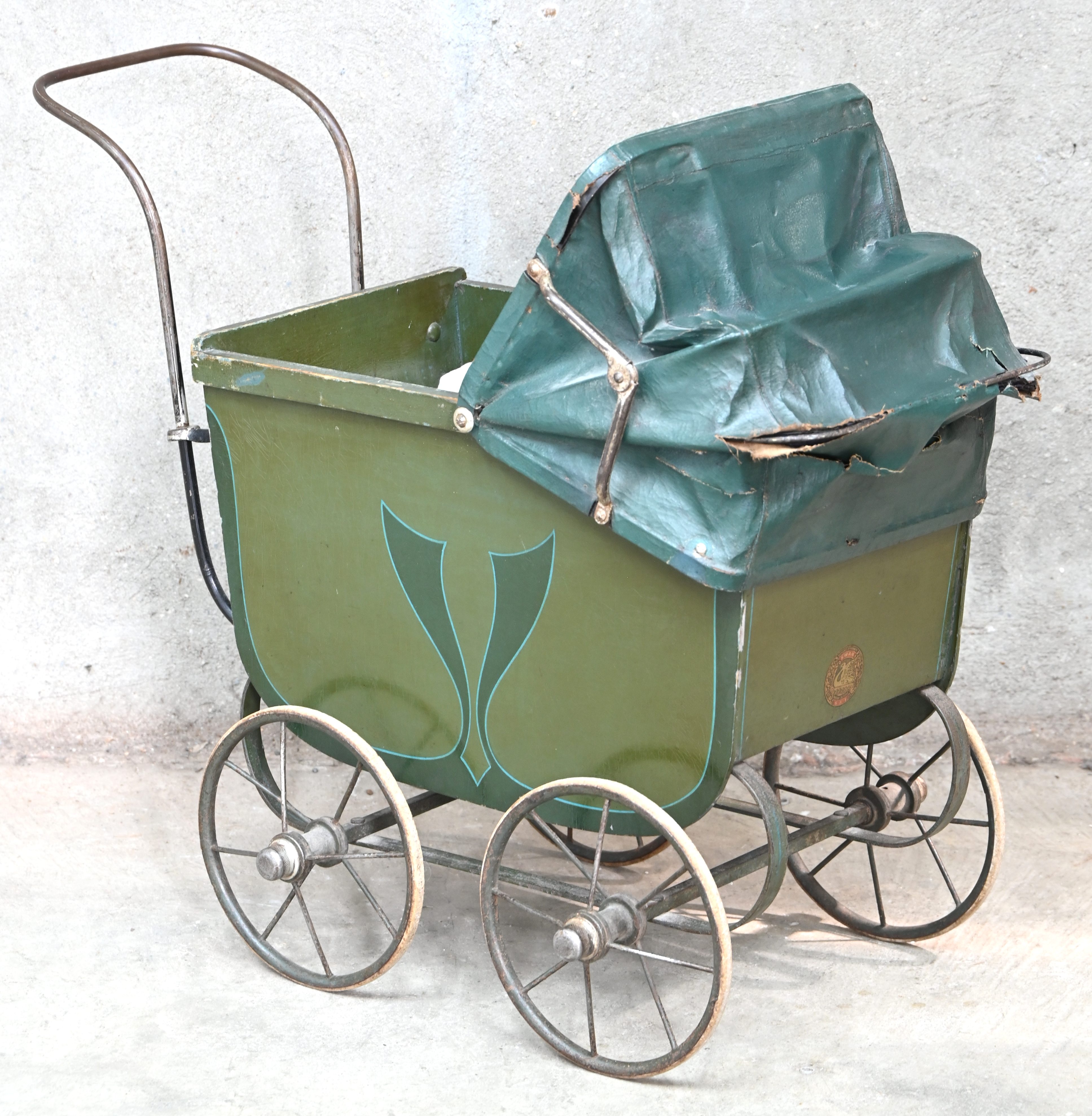 Een antieke poppenwagen gemerkt Swan. Circa 1910. Gescheurde kap Een antieke poppenwagen gemerkt Swan. Circa 1910. Gescheurde kap.