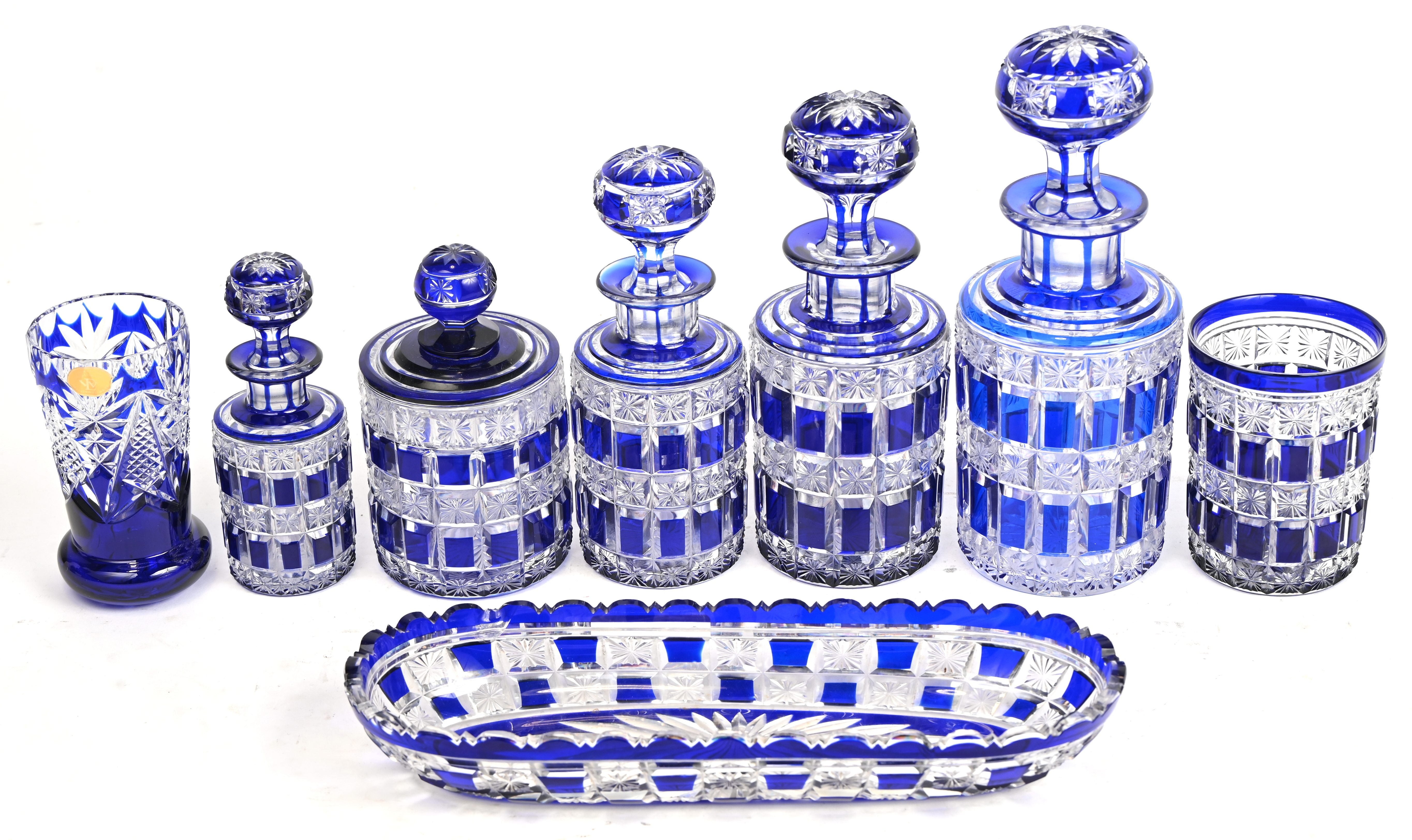 Een kristallen toiletstel, blauw in de massa gekleurd, bestaande uit 4 karafjes, een dekselpotje, 2 glazen en een schaaltje. Schilfer van het schaaltje. Toegevoegd een extra dop Een kristallen toiletstel, blauw in de massa gekleurd, bestaande uit 4 karafjes, een dekselpotje, 2 glazen en een schaaltje. Schilfer van het schaaltje. Toegevoegd een extra dop.