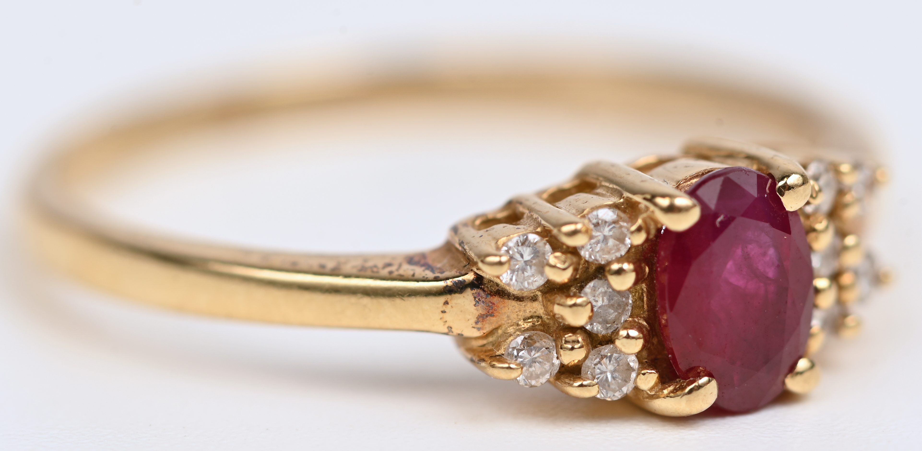 Een 18 kt geelgouden ring bezet met een centrale robijn van +- 0,35 ct. en 10 kleine briljantjes. Met certificaat Een 18 kt geelgouden ring bezet met een centrale robijn van +- 0,35 ct. en 10 kleine briljantjes. Met certificaat.