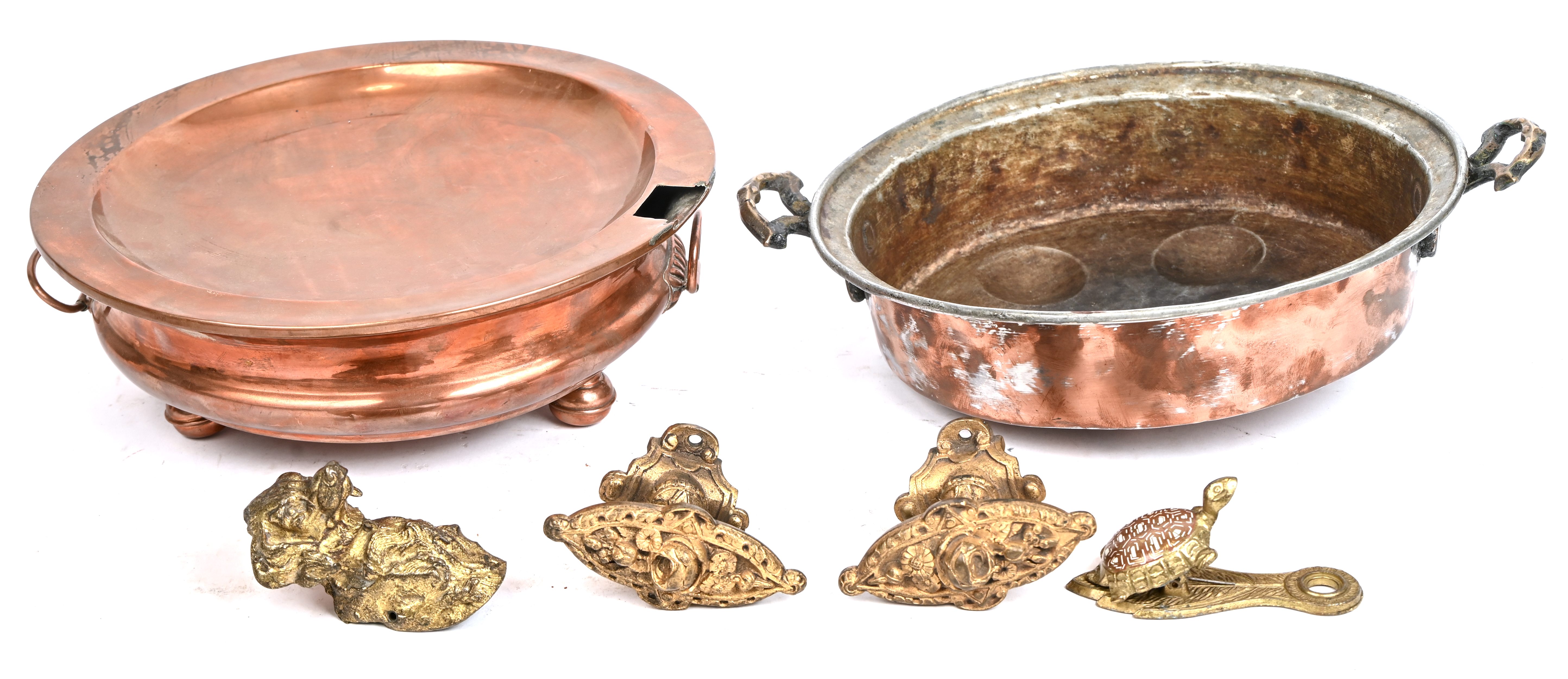 Een lot oud koper bestaande uit een bain-marie schaal, een eierpocheerpan, 2 handvatten, een brievenklem in de vorm van een schildpad en een buste van een hond Een lot oud koper bestaande uit een bain-marie schaal, een eierpocheerpan, 2 handvatten, een brievenklem in de vorm van een schildpad en een buste van een hond.