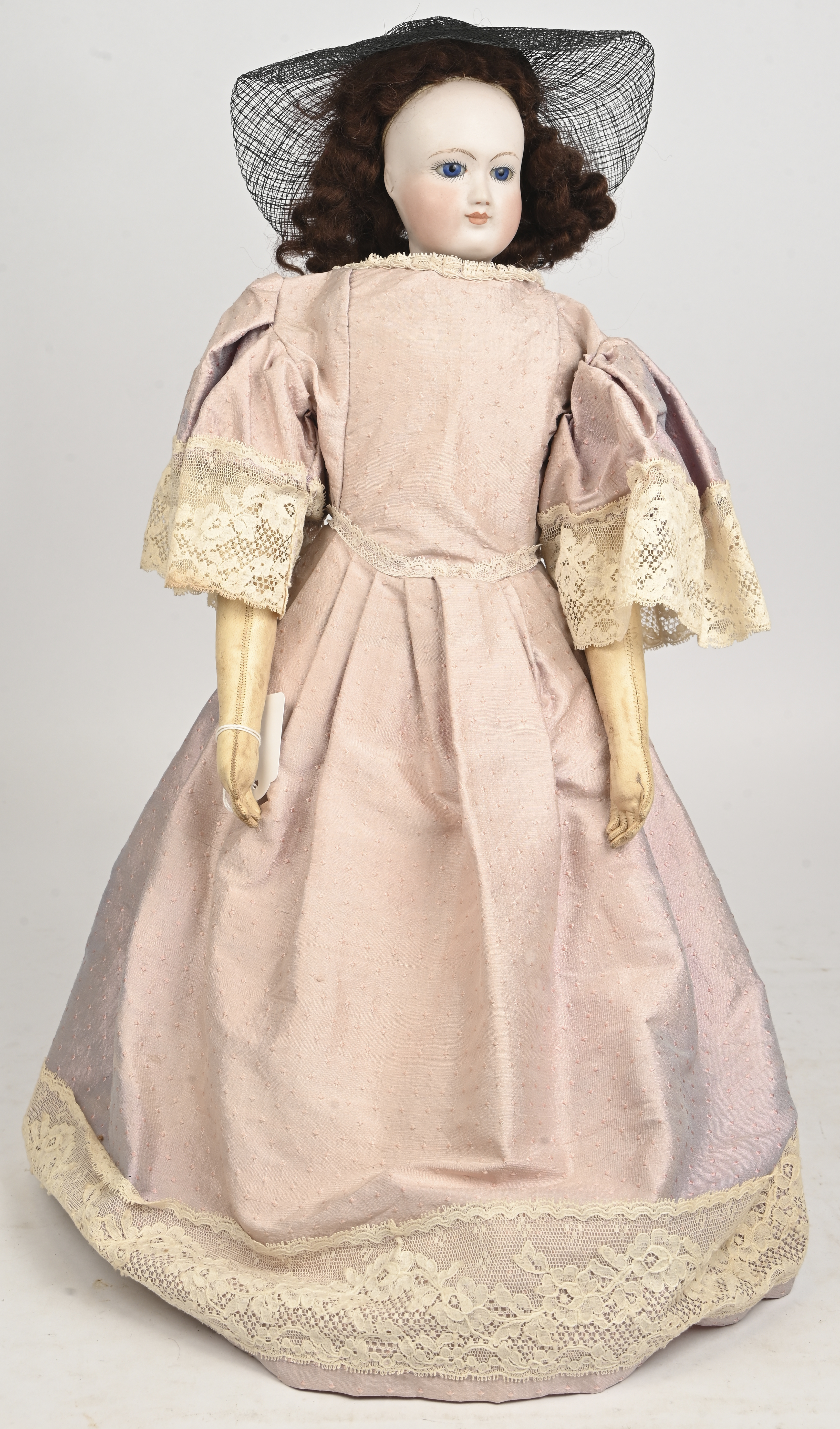 Antieke mannequinpop. Vaste ogen, gesloten mond, lange roze jurk met kant en zwarte hoed met voile. Gemerkt gekruiste pijlen en S. Lederen lichaam en ledematen. Prima staat. Op statief Antieke mannequinpop. Vaste ogen, gesloten mond, lange roze jurk met kant en zwarte hoed met voile. Gemerkt gekruiste pijlen en S. Lederen lichaam en ledematen. Prima staat. Op statief.
