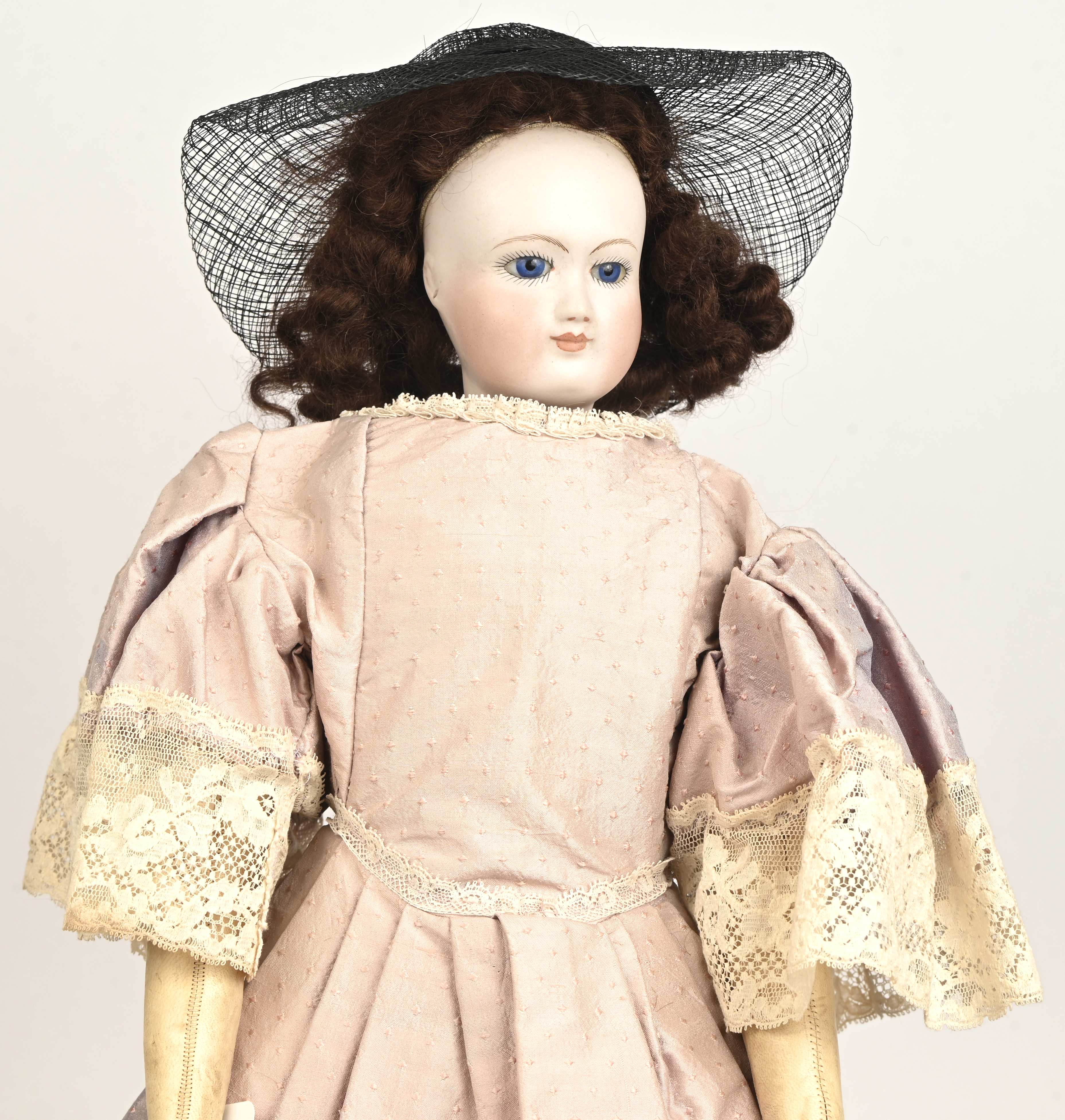 Antieke mannequinpop. Vaste ogen, gesloten mond, lange roze jurk met kant en zwarte hoed met voile. Gemerkt gekruiste pijlen en S. Lederen lichaam en ledematen. Prima staat. Op statief Antieke mannequinpop. Vaste ogen, gesloten mond, lange roze jurk met kant en zwarte hoed met voile. Gemerkt gekruiste pijlen en S. Lederen lichaam en ledematen. Prima staat. Op statief.