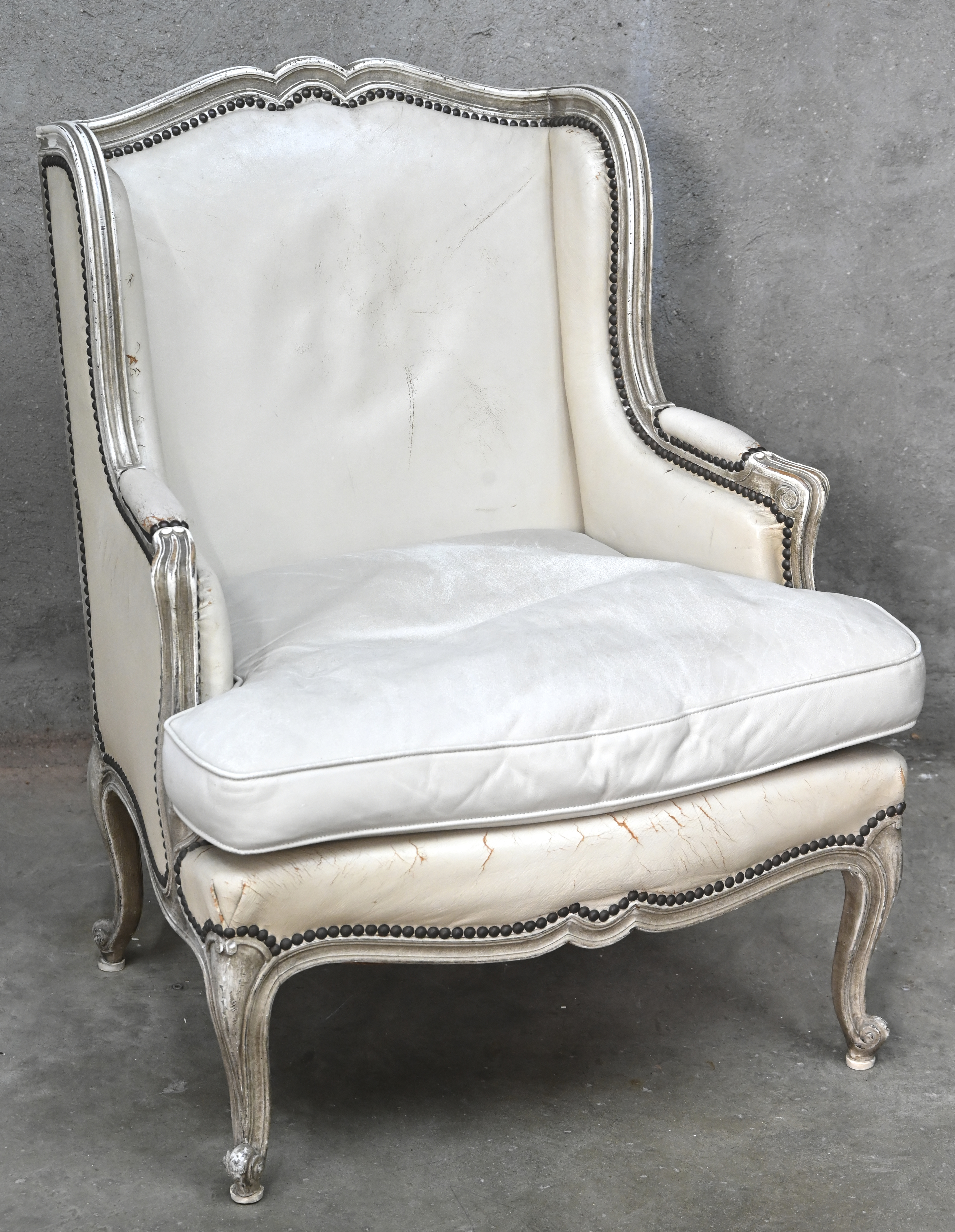 Een wit lederen eenzit in Louis XV-stijl Een wit lederen eenzit in Louis XV-stijl.