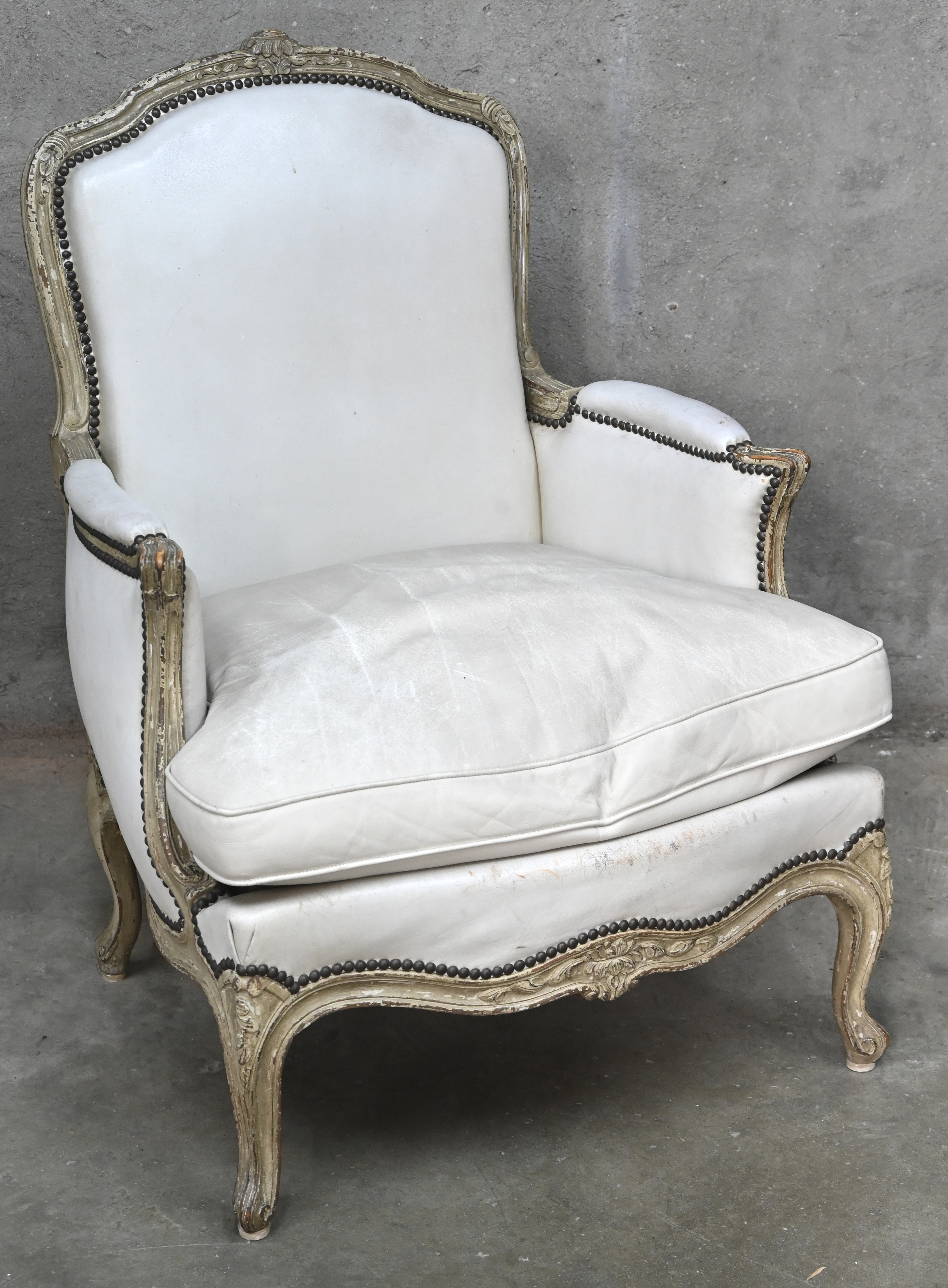 Een wit lederen eenzit in Louis XV-stijl Een wit lederen eenzit in Louis XV-stijl.