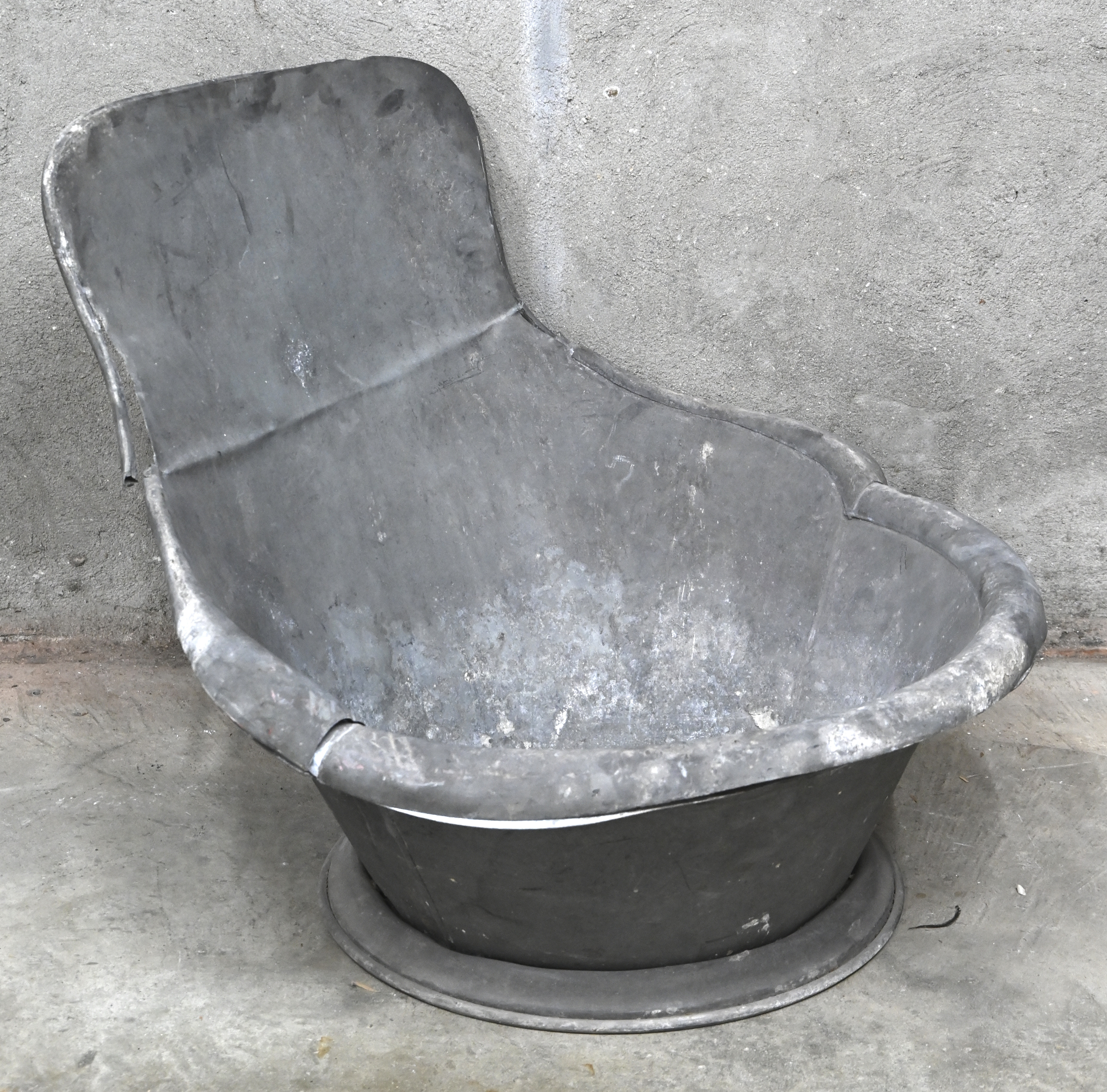 Een antiek zinken zitbad met rugleuning Een antiek zinken zitbad met rugleuning.