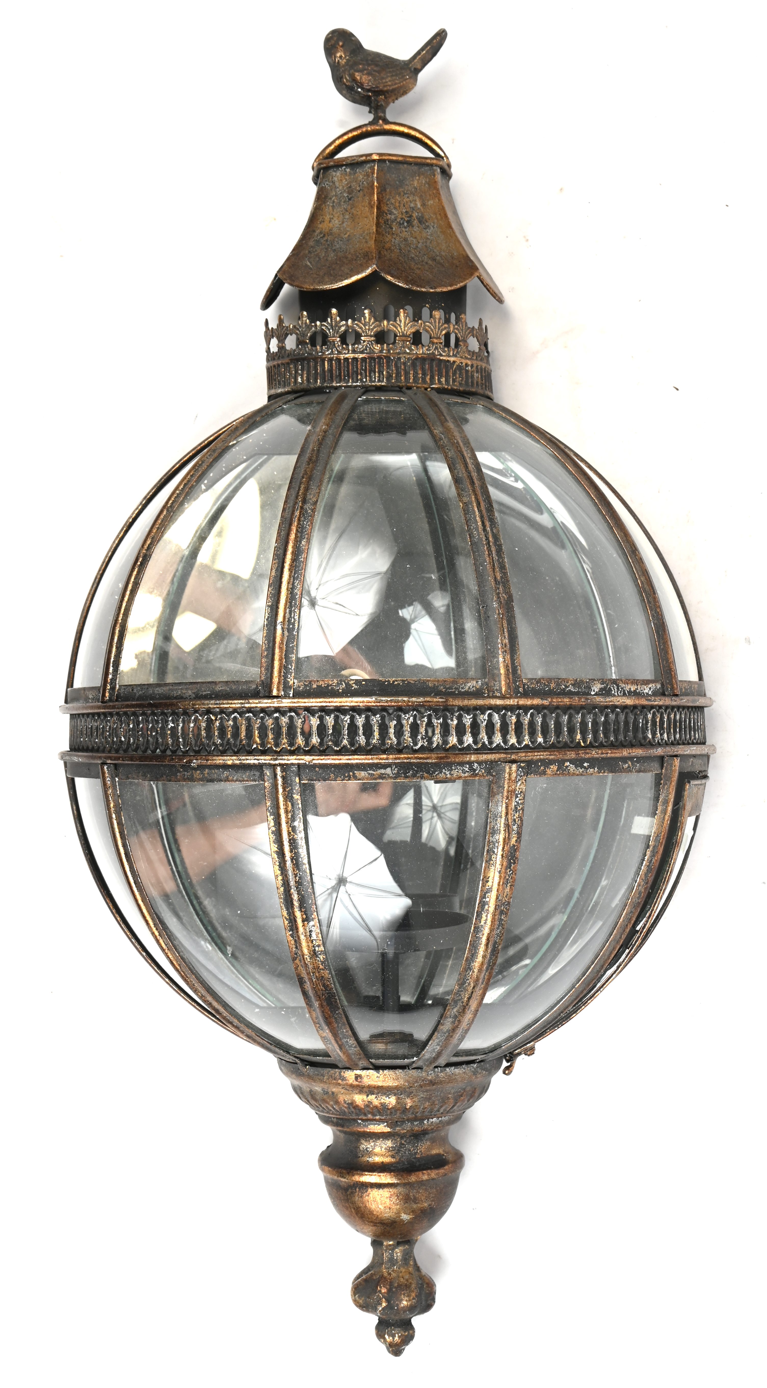 Een half ronde metalen wandlantaarn met glas en vogel op top Een half ronde metalen wandlantaarn met glas en vogel op top.