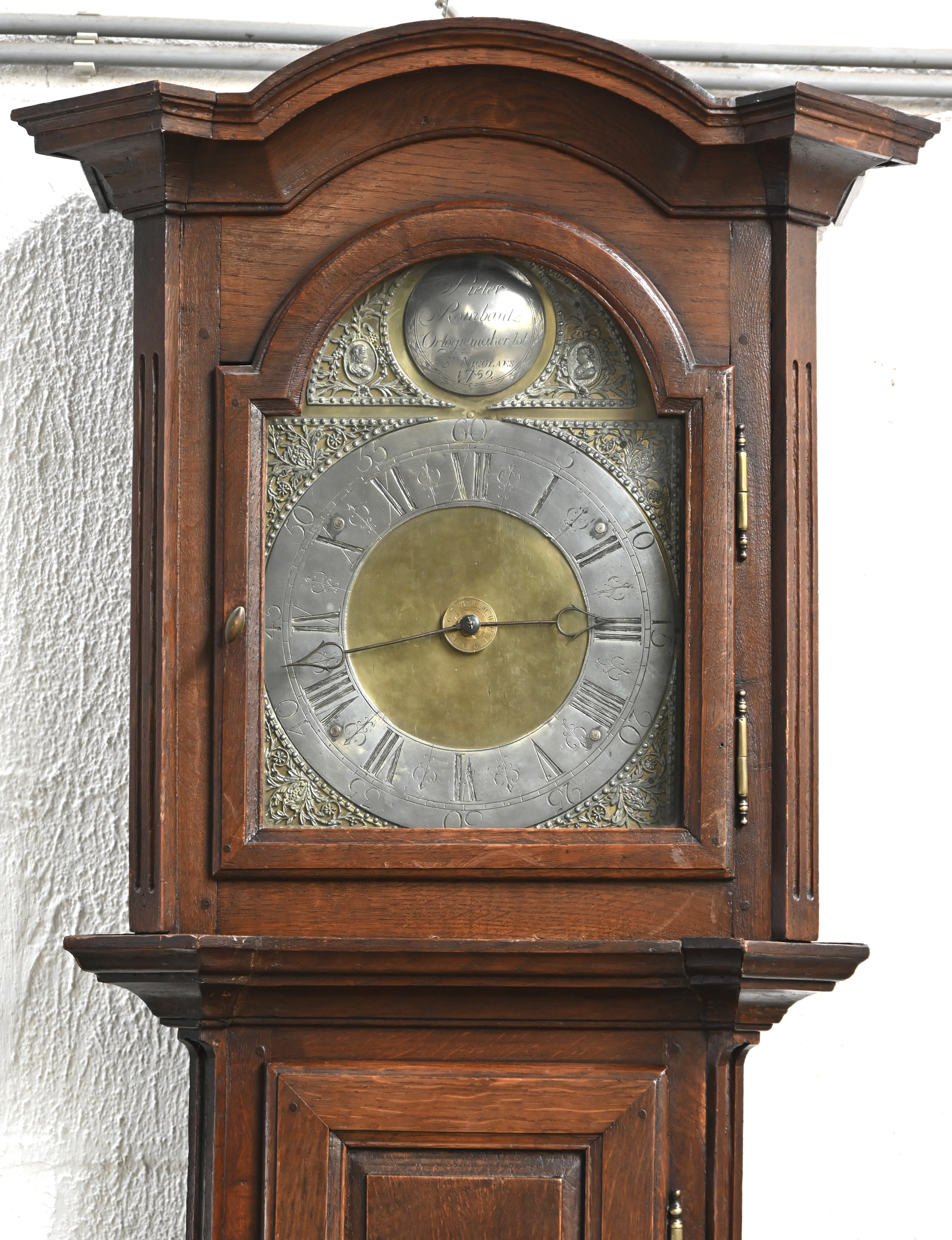 Een staande klok in eikenhouten kast, met opschrift Pieter Rombaut, Orlogemaker tot Ste Nicolaes 1752. Kast uit de XIXde eeuw. Met slinger en gewichten Een staande klok in eikenhouten kast, met opschrift Pieter Rombaut, Orlogemaker tot Ste Nicolaes 1752. Kast uit de XIXde eeuw. Met slinger en gewichten.