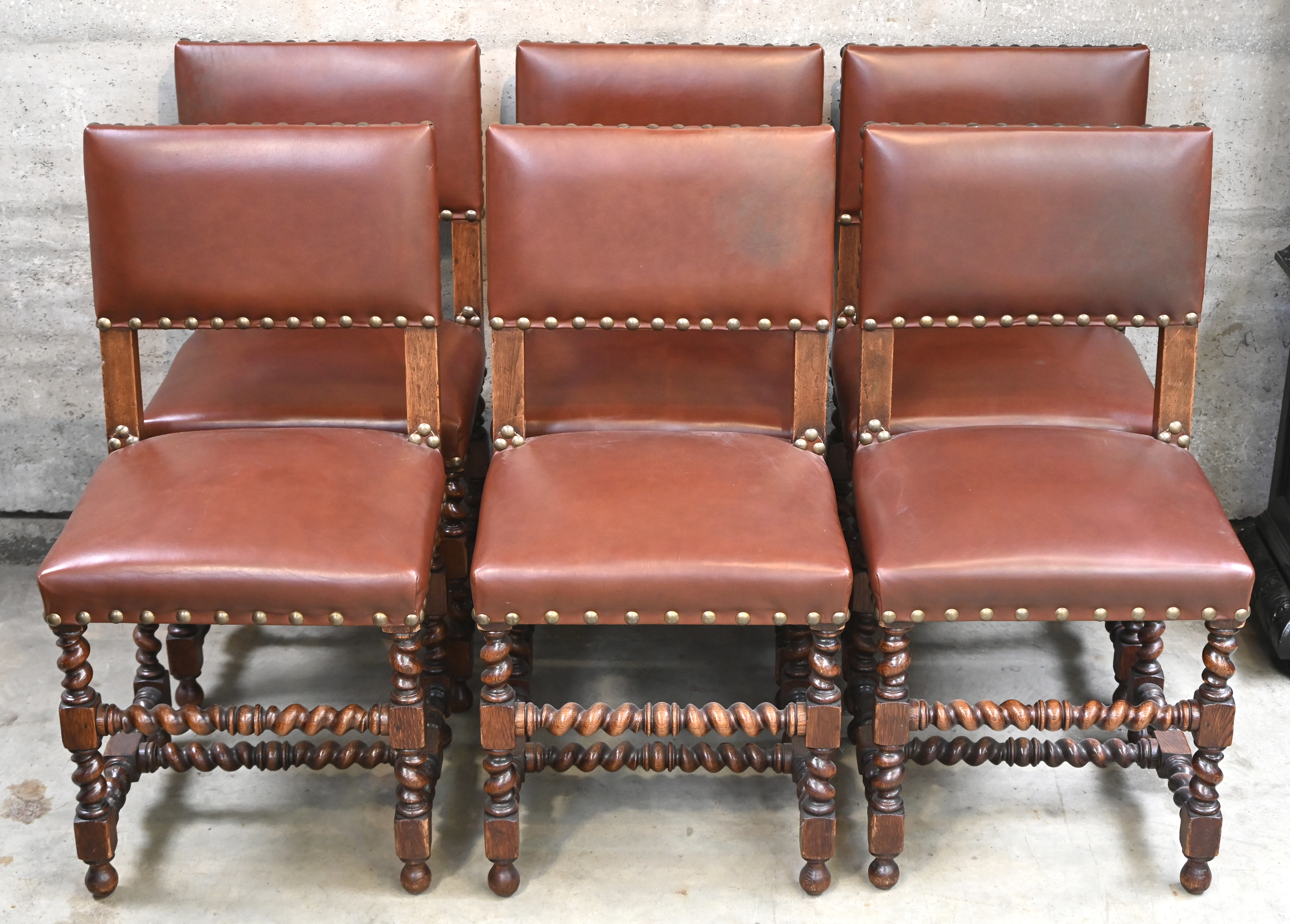 Een serie van 6 eikenhouten stoelen in renaissance stijl, bekleed met leder en voorzien van grote koperen siernagels Een serie van 6 eikenhouten stoelen in renaissance stijl, bekleed met leder en voorzien van grote koperen siernagels.