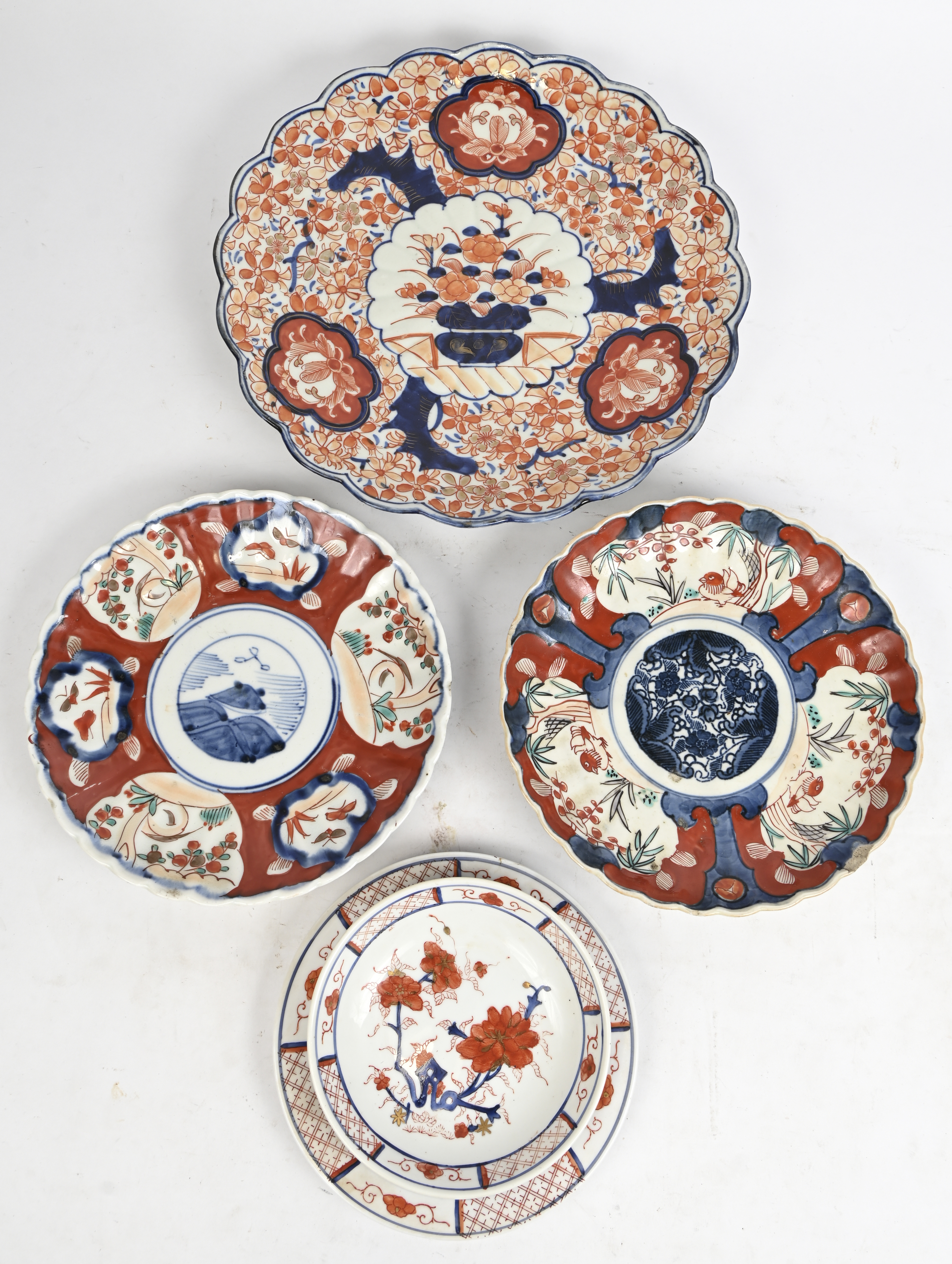 Een lot Imari porseleinen borden. 5 borden, één met schaaltje. Waaronder een laat 19e eeuws bord (met schilfer) Een lot Imari porseleinen borden. 5 borden, één met schaaltje. Waaronder een laat 19e eeuws bord (met schilfer).