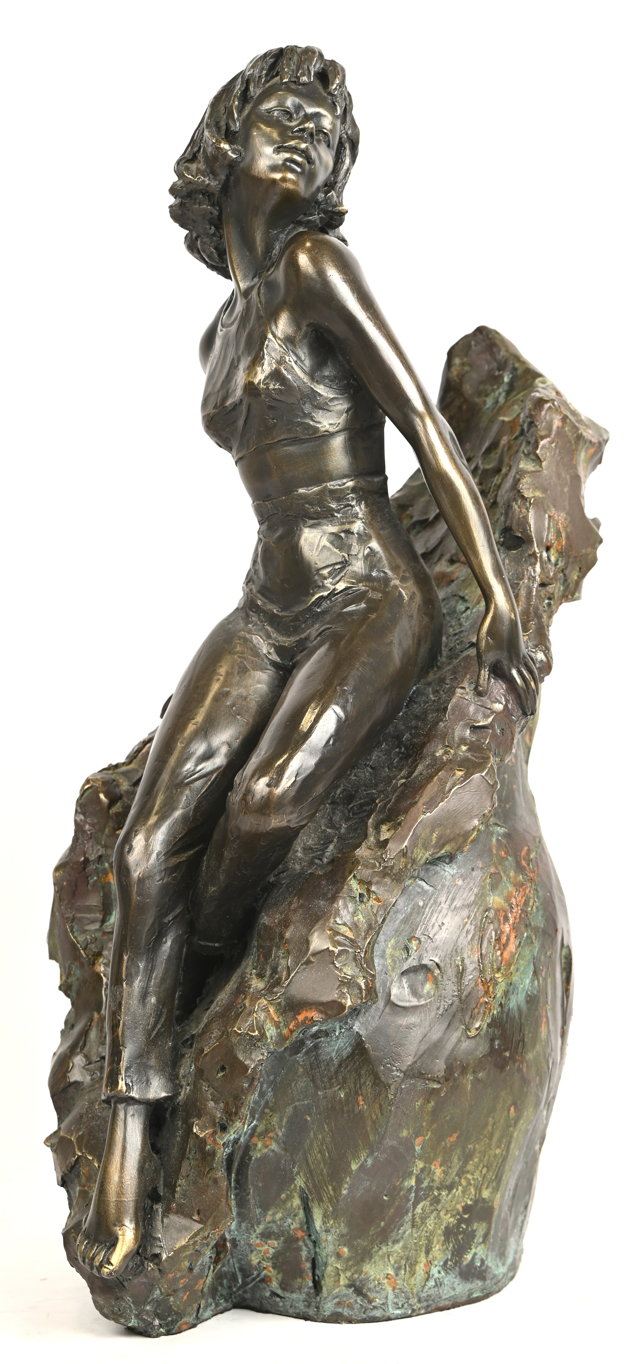 Een bronzen beeld van een jongedame, gezeten tegen een rots. Gesigneerd Een bronzen beeld van een jongedame, gezeten tegen een rots. Gesigneerd.