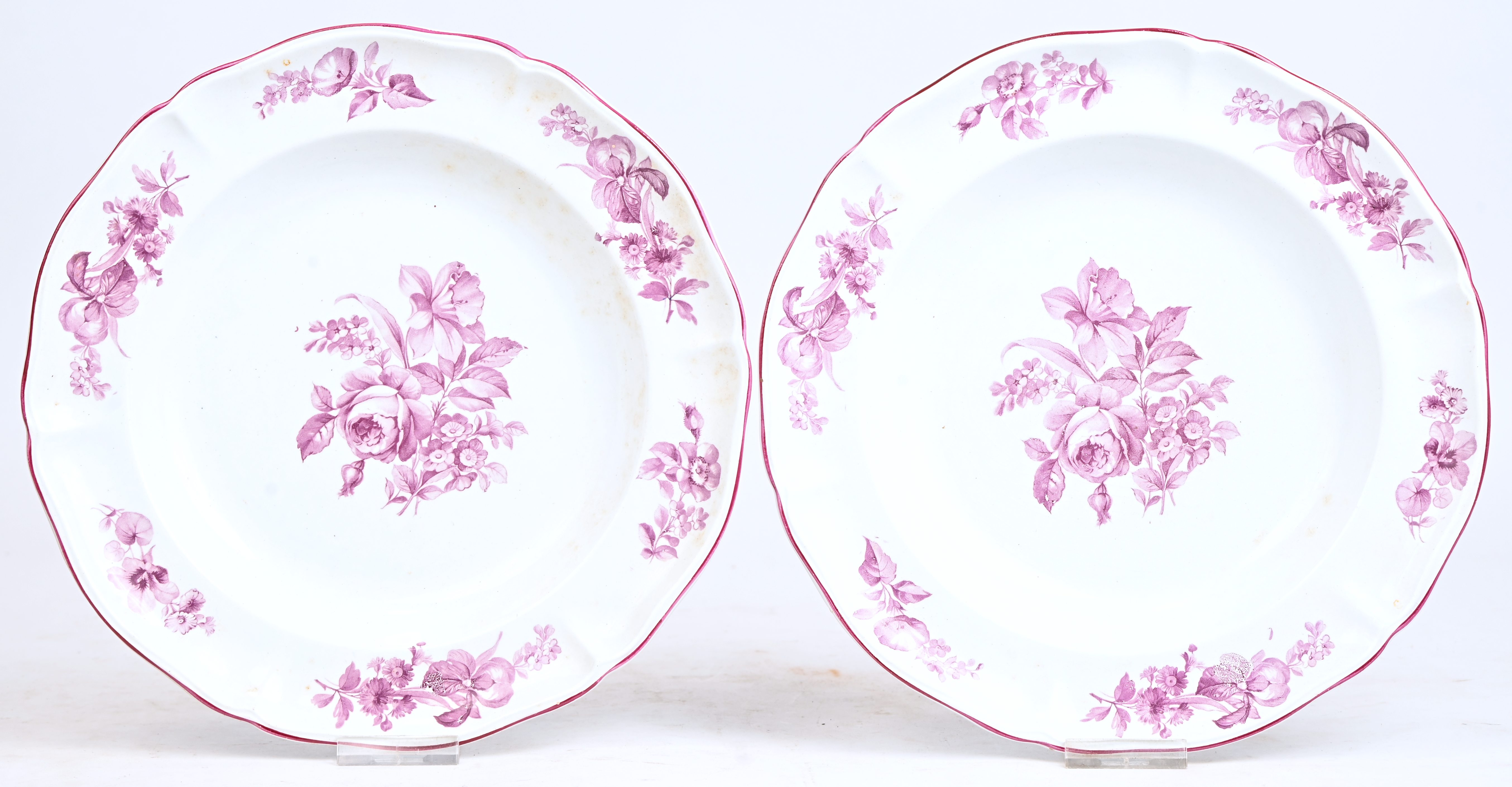 Een paar diepe borden van zachte pasta met een camaïeudecor van bloementuilen in mangaankleur. Gechantourneerde rand met een mangaankleurige bies. Onderaan gemerkt boven glazuur en met modelnummer K 2.399 gestanst. Omstreeks 1900 Een paar diepe borden van zachte pasta met een camaïeudecor van bloementuilen in mangaankleur. Gechantourneerde rand met een mangaankleurige bies. Onderaan gemerkt boven glazuur en met modelnummer K 2.399 gestanst. Omstreeks 1900.