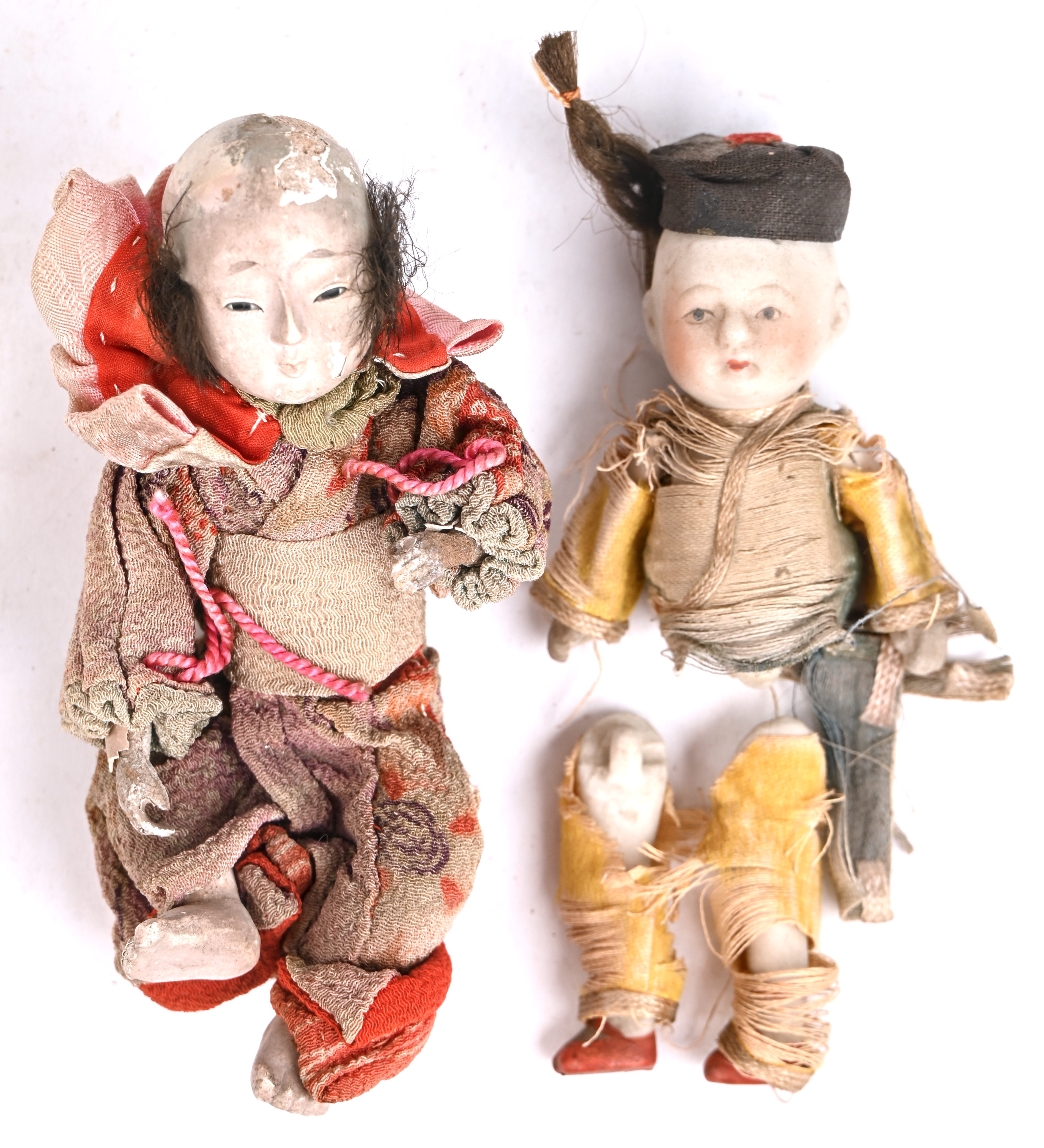 Twee oude Japanse popjes, één uit porselein (benen los), en één uit papier-maché (schade a/h hoofd Twee oude Japanse popjes, één uit porselein (benen los), en één uit papier-maché (schade a/h hoofd.