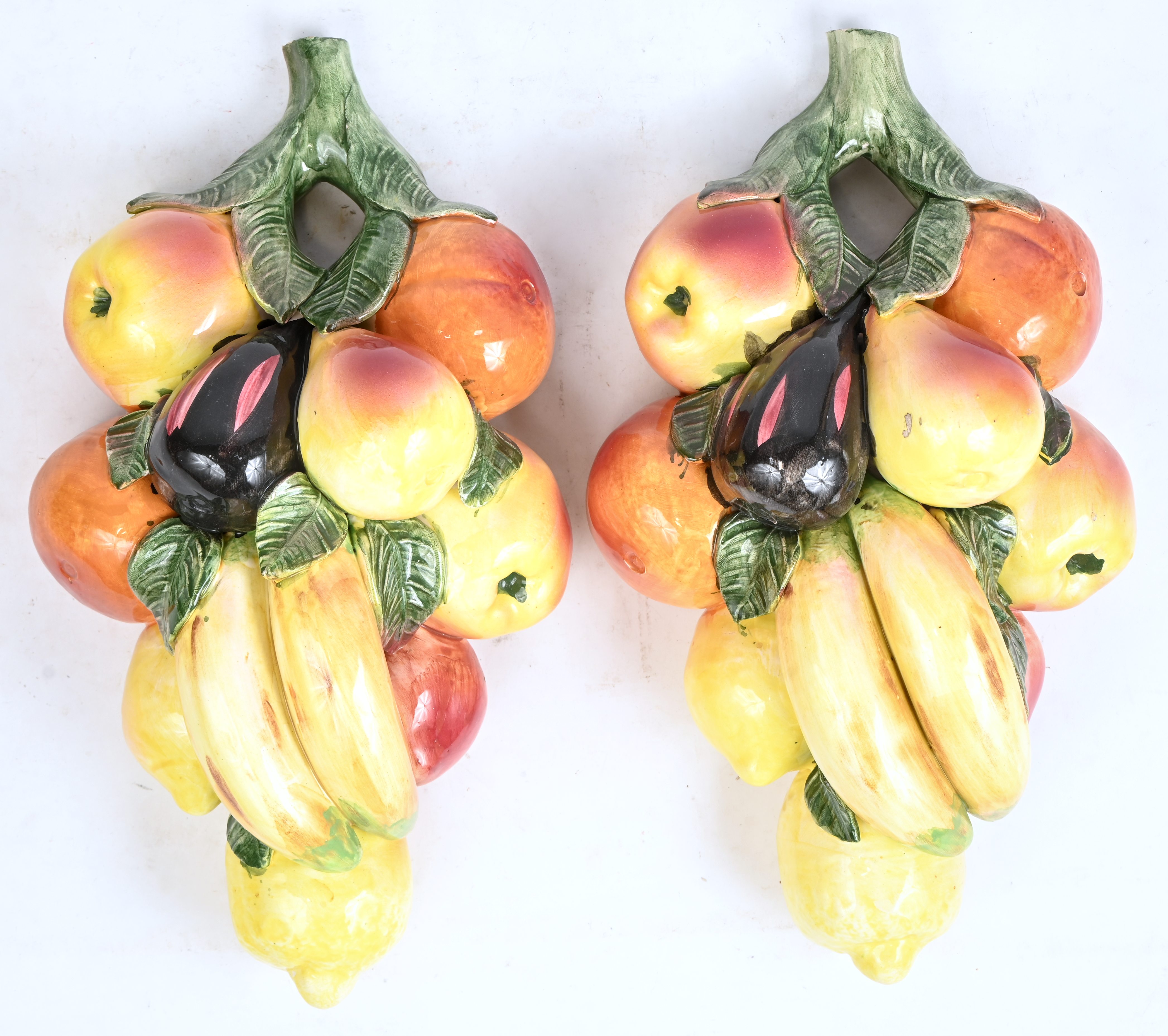 Twee groepjes decoratief fruit, van meerkleurig Italiaans aardewerk. Niet gesigneerd Twee groepjes decoratief fruit, van meerkleurig Italiaans aardewerk. Niet gesigneerd.