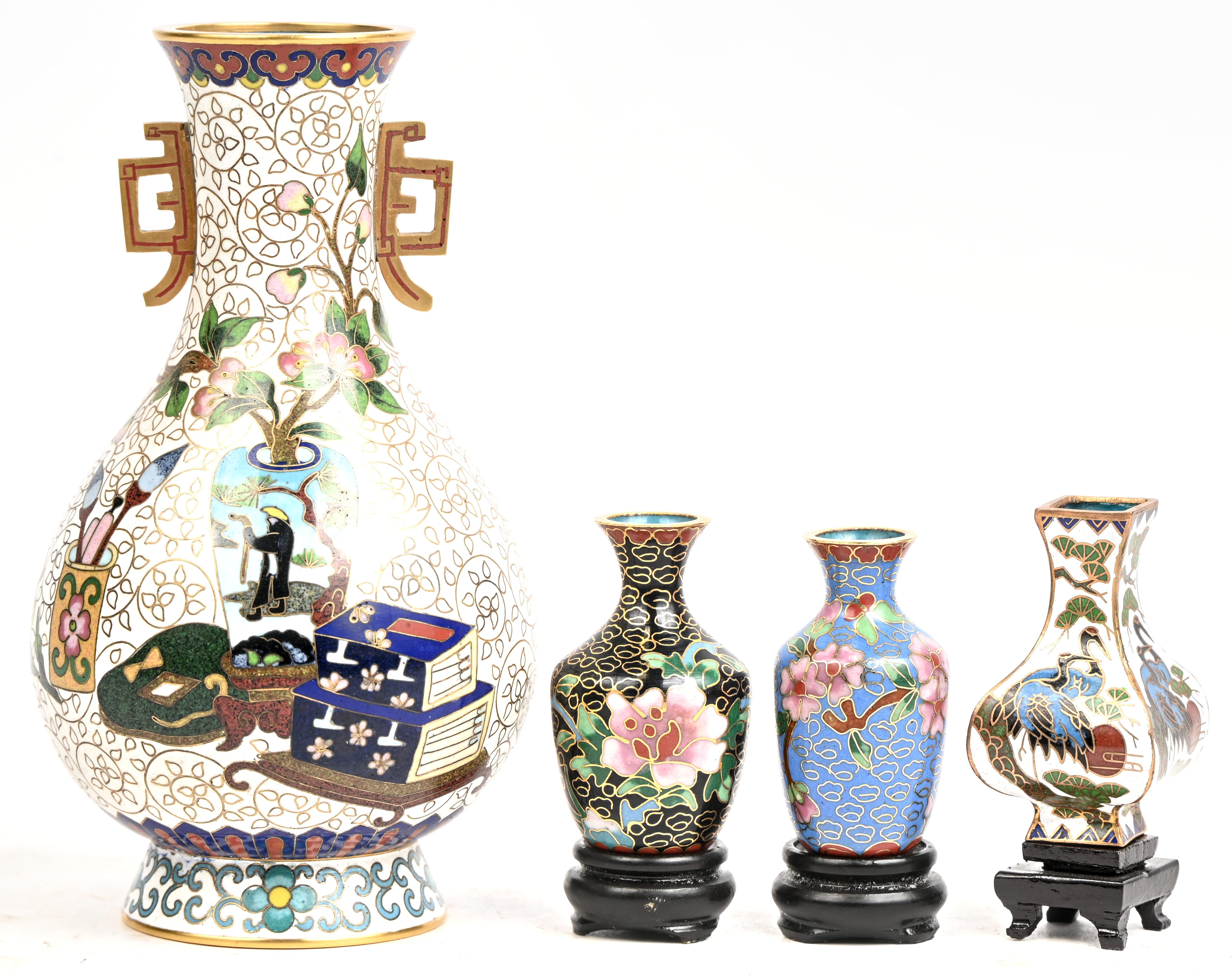 Een lot cloisoné bestaande uit 4 bordjes, 2 asbakken en 4 vaasjes waarvan de 3 kleinste op houten sokkeltje Een lot cloisoné bestaande uit 4 bordjes, 2 asbakken en 4 vaasjes waarvan de 3 kleinste op houten sokkeltje.