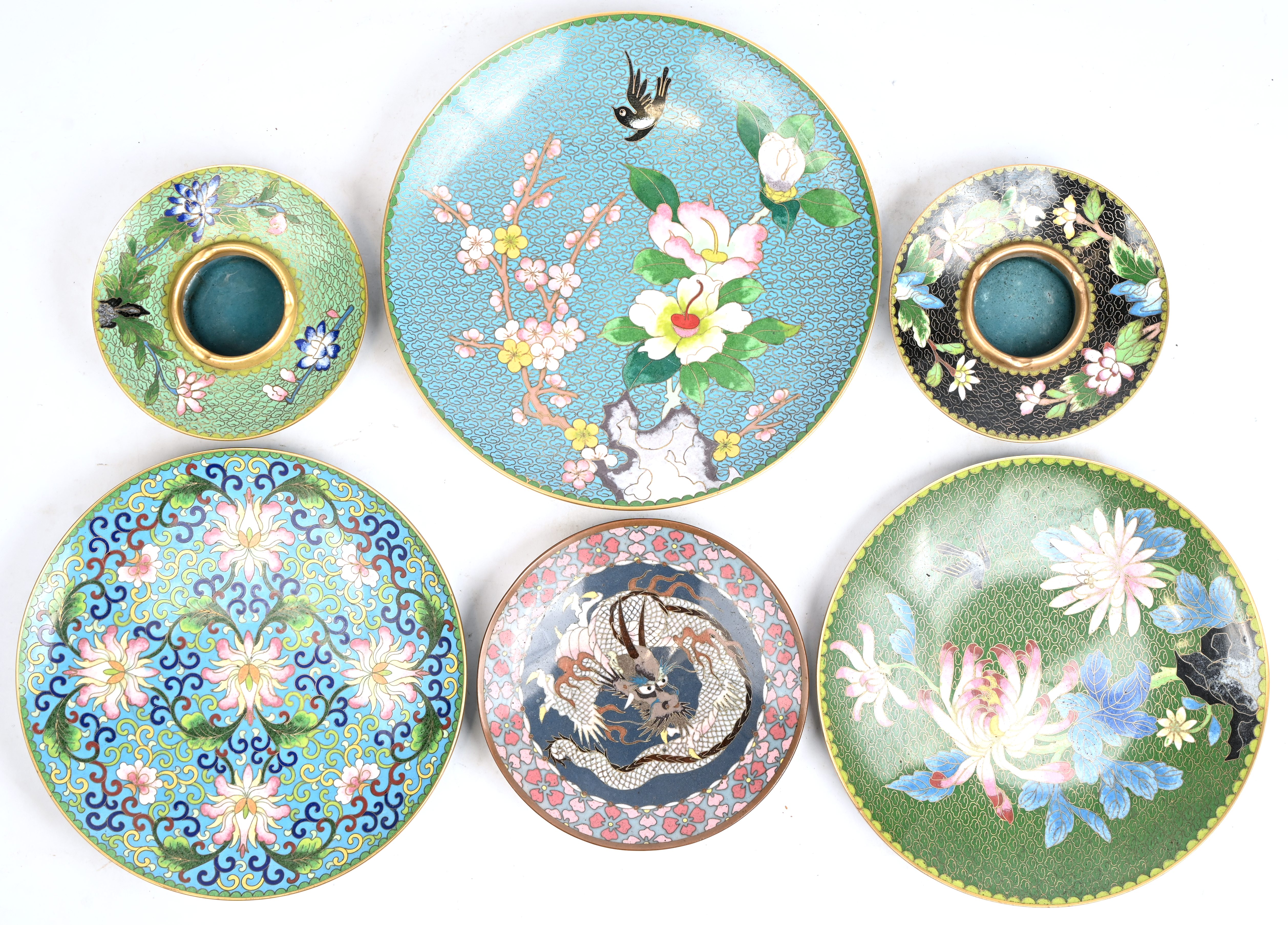 Een lot cloisoné bestaande uit 4 bordjes, 2 asbakken en 4 vaasjes waarvan de 3 kleinste op houten sokkeltje Een lot cloisoné bestaande uit 4 bordjes, 2 asbakken en 4 vaasjes waarvan de 3 kleinste op houten sokkeltje.