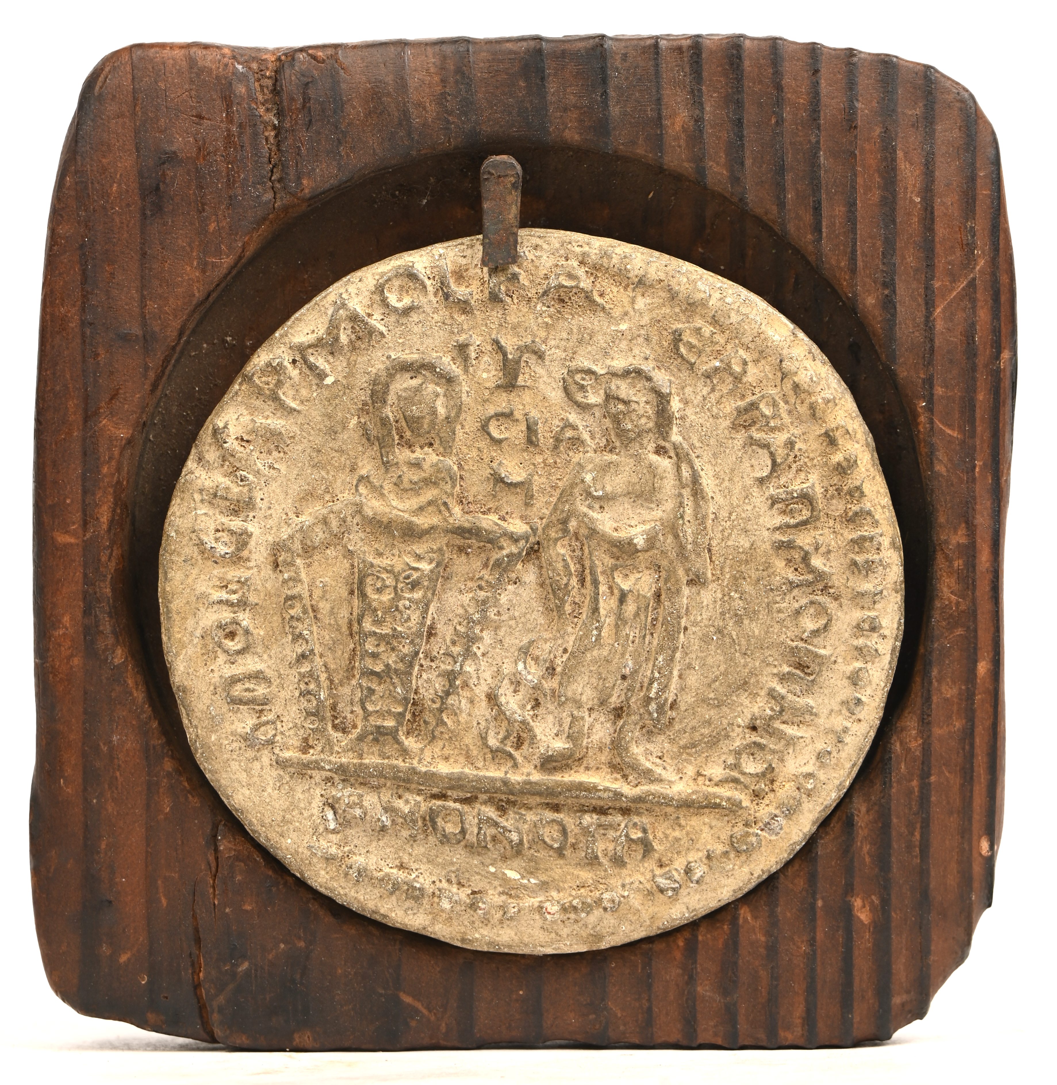 Een afgietsel van een bronzen penning naar oud voorbeeld. Steengoed. In houten kader Een afgietsel van een bronzen penning naar oud voorbeeld. Steengoed. In houten kader.