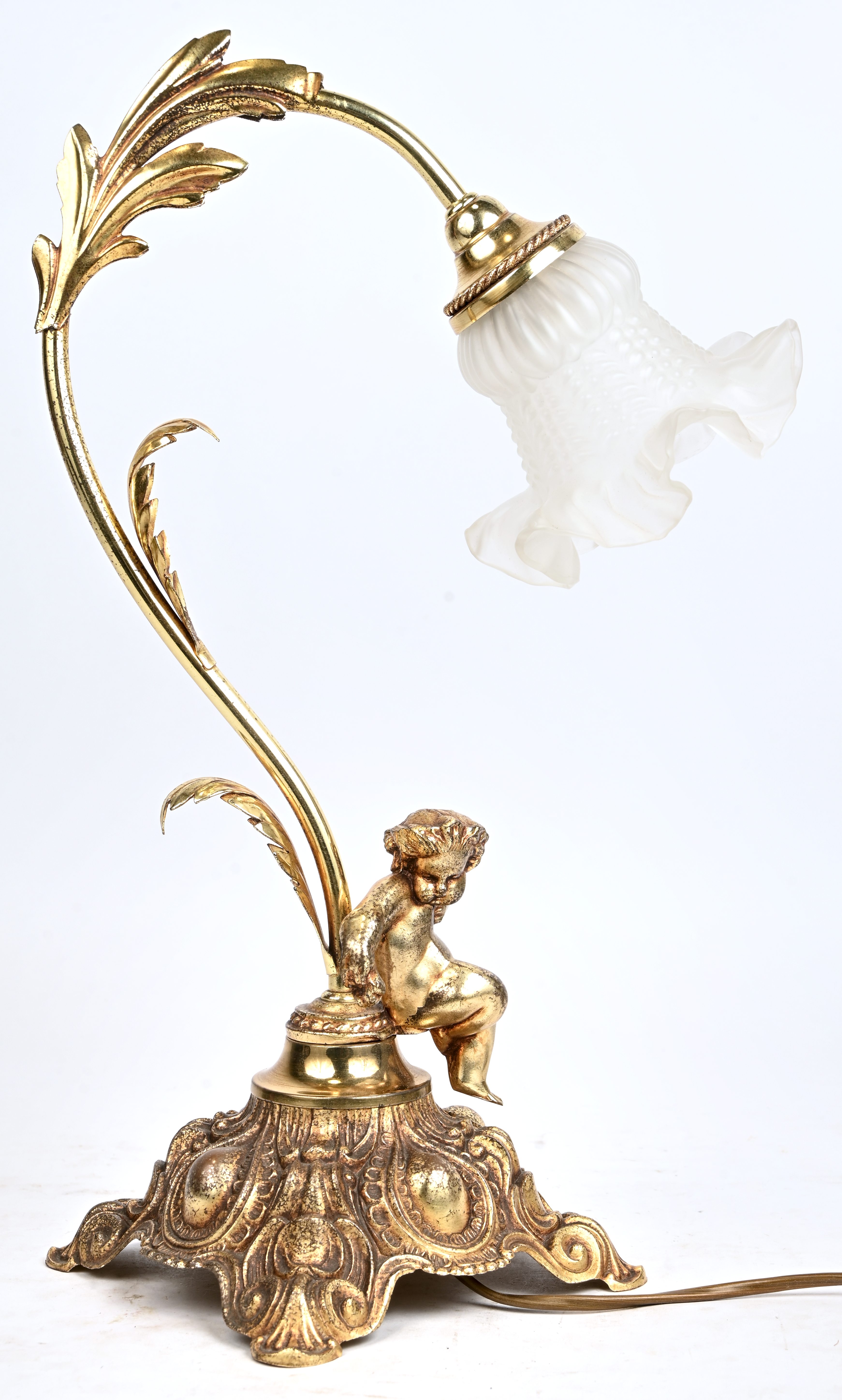 Een verguld koperen tafellamp met putti, bloemvormige melkglas blaker Een verguld koperen tafellamp met putti, bloemvormige melkglas blaker.