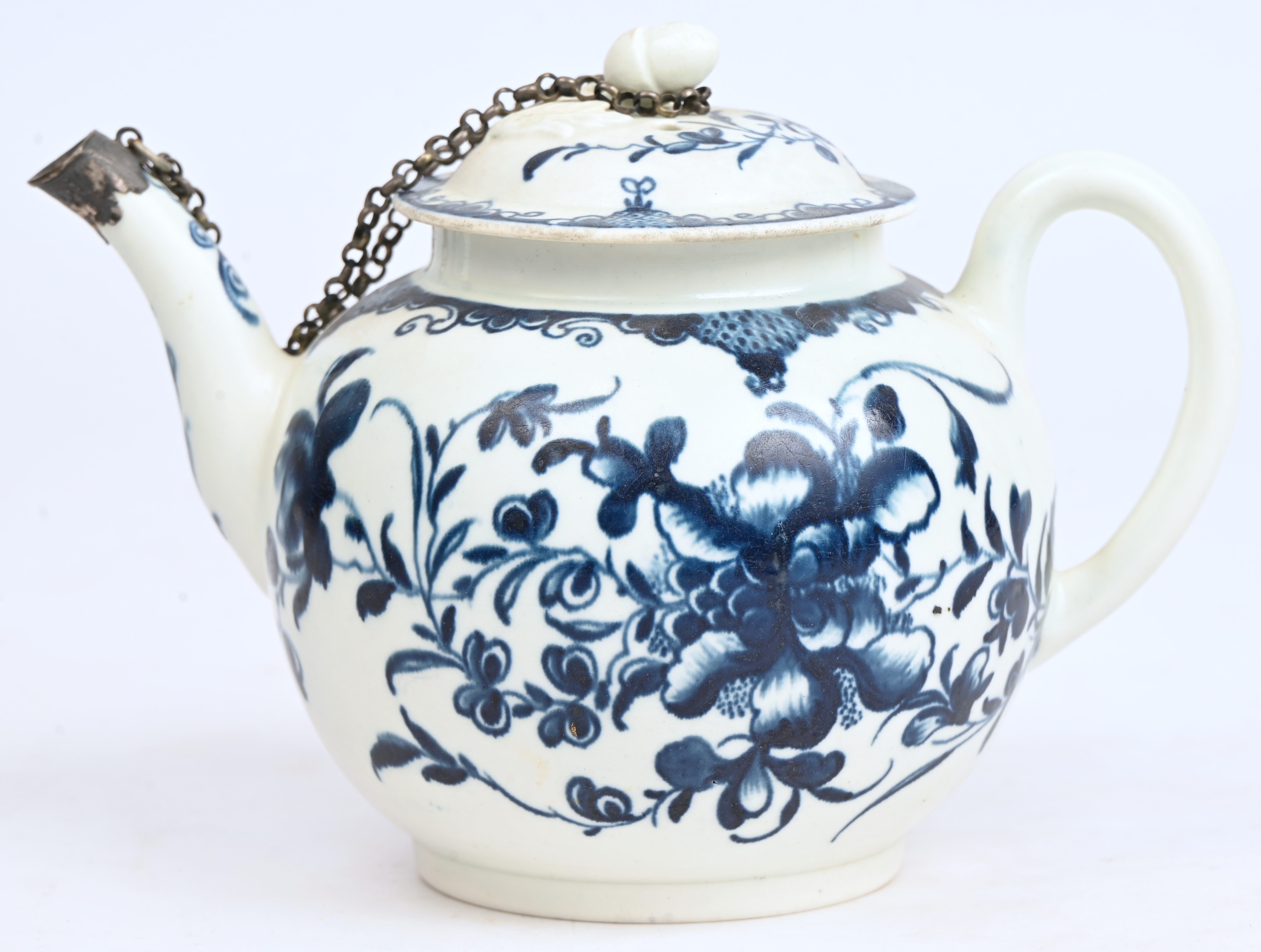 Kleine theepot met een blauw en wit decor van planten en bloemen en met een Lodewijk XV-fries. Dekselknop in de vorm van een eikel met blad. Doornik, tweede periode. Gemerkt met een maansegment en voorzien van een zilveren montuurtje aan de tuit Kleine theepot met een blauw en wit decor van planten en bloemen en met een Lodewijk XV-fries. Dekselknop in de vorm van een eikel met blad. Doornik, tweede periode. Gemerkt met een maansegment en voorzien van een zilveren montuurtje aan de tuit.