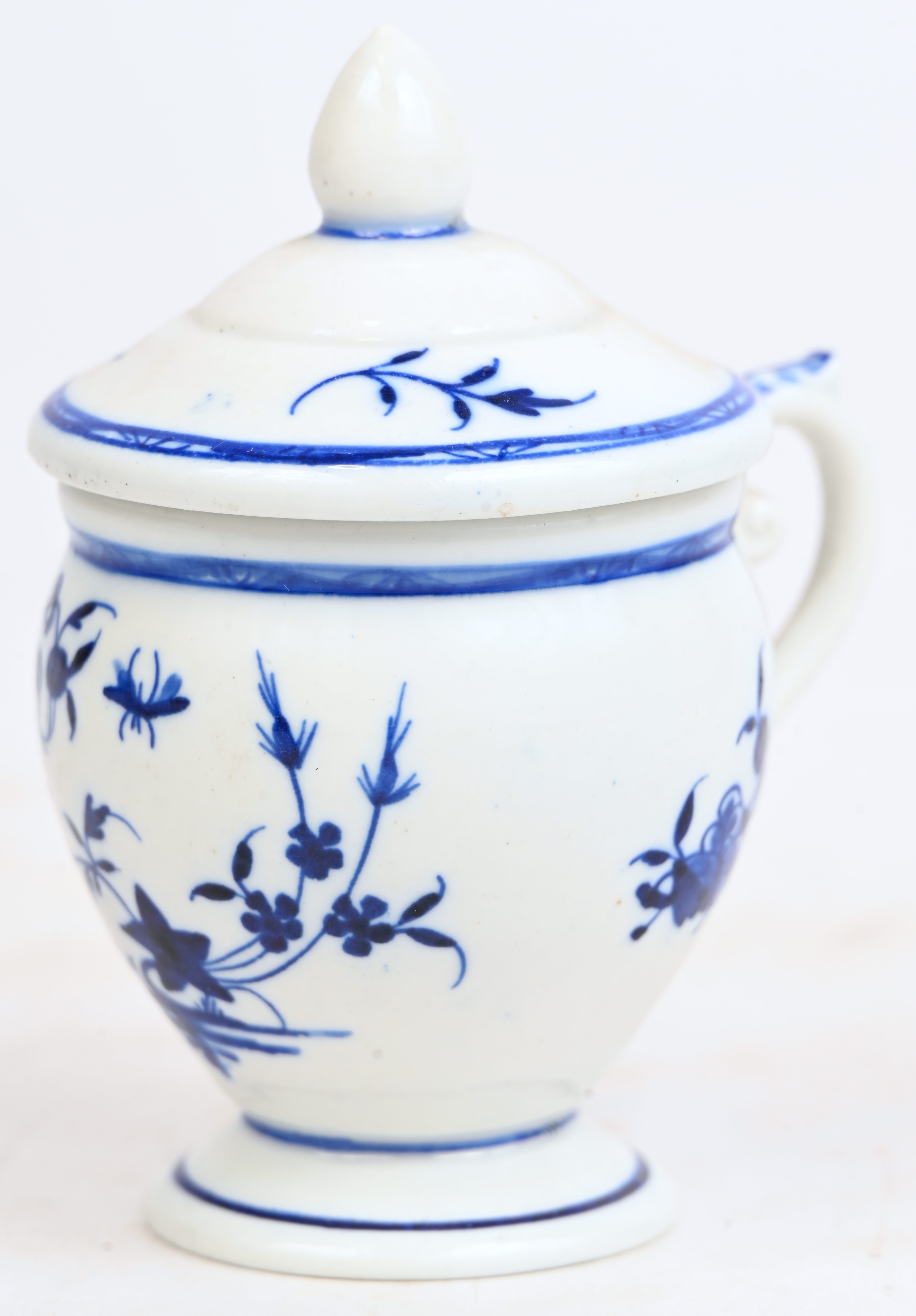 Een roompotje van zachte pasta op voetstuk. Blauw “décor à la mouche”. Kolvormig oor, dekselknop in toortsvorm. Randen blauw afgelijnd. Doornik, begin XIXde eeuw Een roompotje van zachte pasta op voetstuk. Blauw “décor à la mouche”. Kolvormig oor, dekselknop in toortsvorm. Randen blauw afgelijnd. Doornik, begin XIXde eeuw.