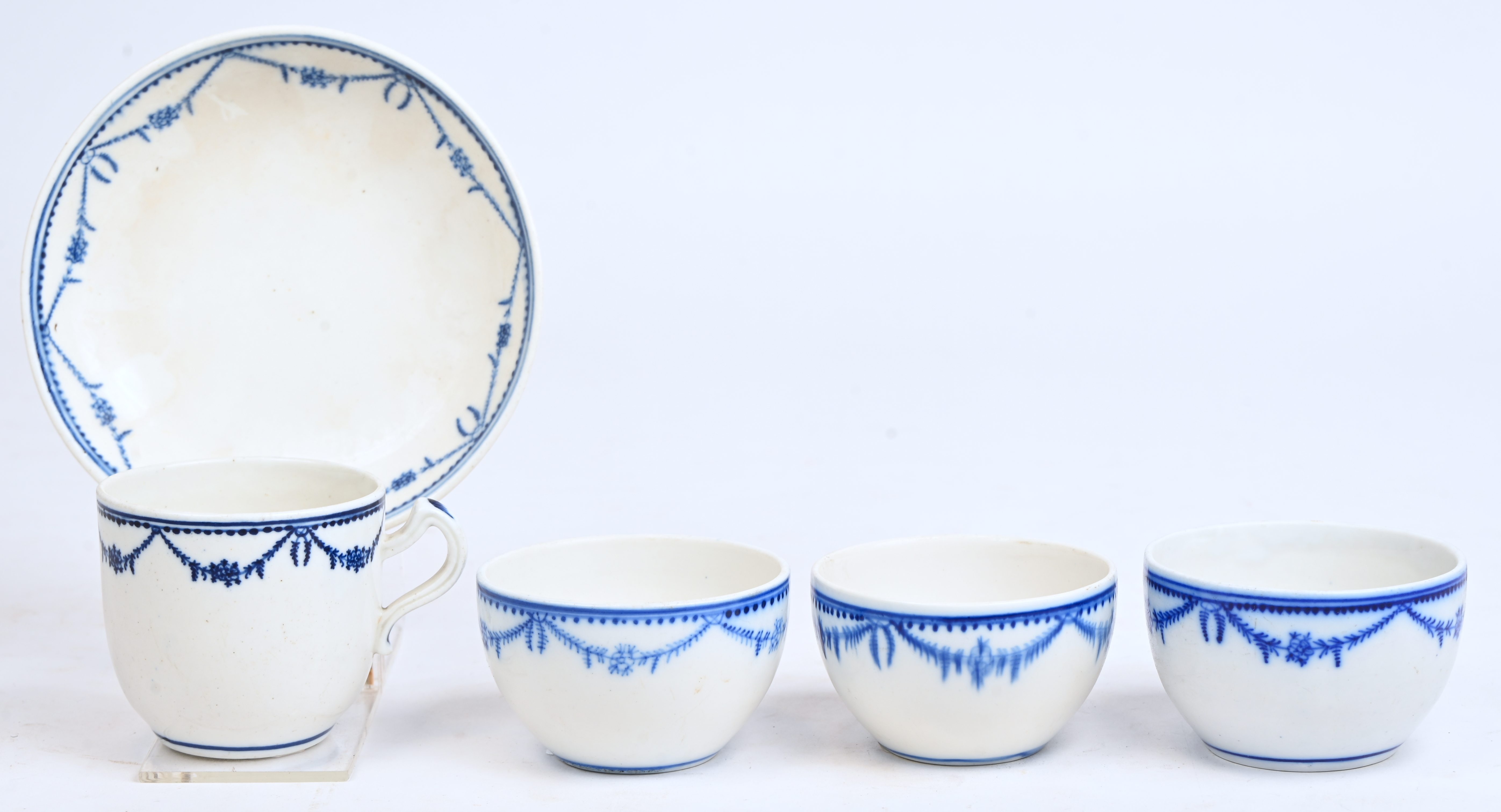 Drie pochons en een kopje met oor, evenals een schoteltje (gemerkt) van zachte pasta met Lodewijk XVI-guirlande-decor. Doornik, XIXde eeuw Drie pochons en een kopje met oor, evenals een schoteltje (gemerkt) van zachte pasta met Lodewijk XVI-guirlande-decor. Doornik, XIXde eeuw.