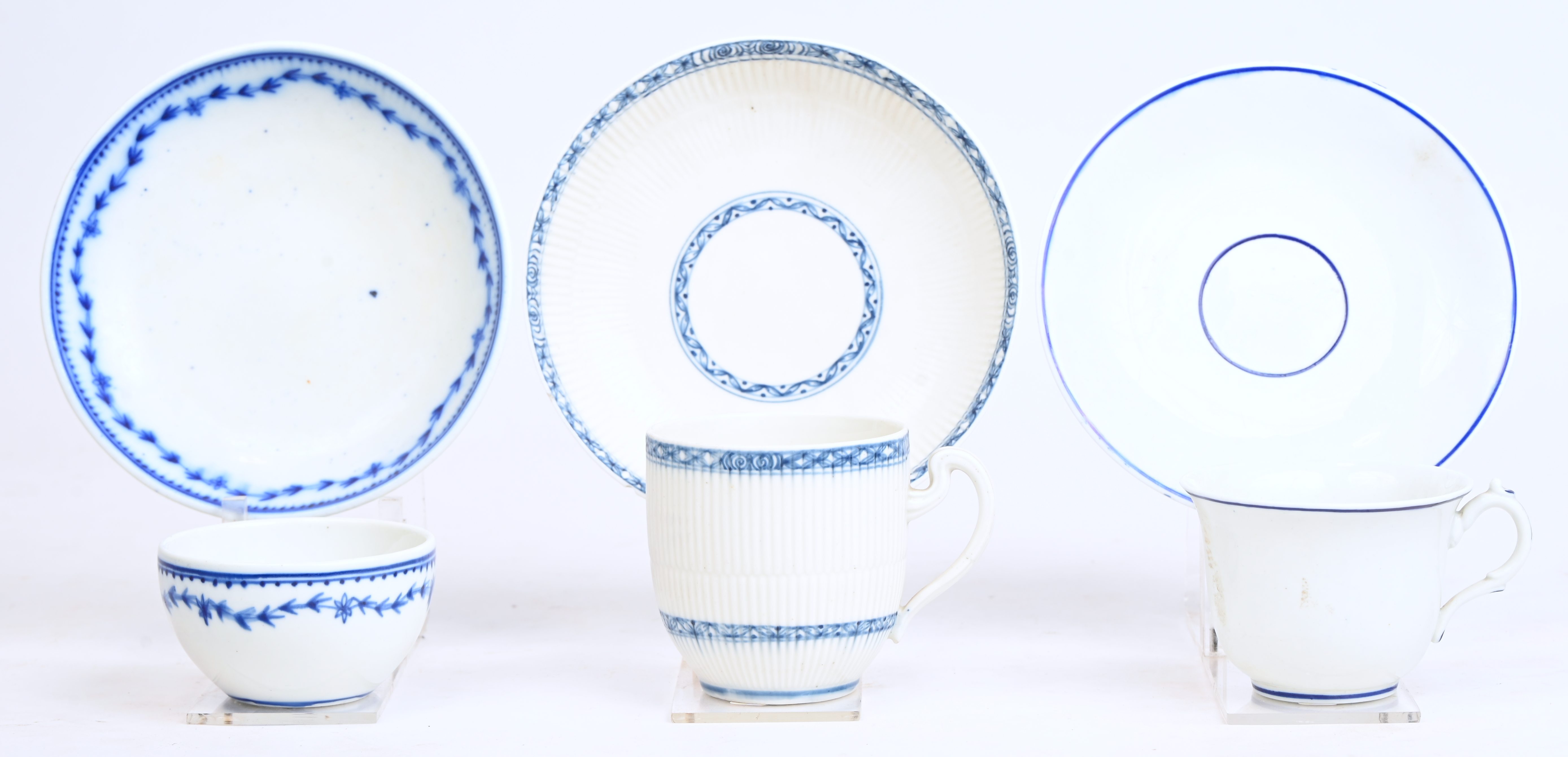 Zes pochons en kopjes met oor met hun schoteltjes. Diverse vormen en blauwe decors. Doornik, XIXde eeuw. Eén stel met speciale randversiering en “1000 ribben”, onderaan gemerkt met de zwaarden en kruisjes, kleine schilfer aan de rand, mogelijk nog XVIIIde eeuw Zes pochons en kopjes met oor met hun schoteltjes. Diverse vormen en blauwe decors. Doornik, XIXde eeuw. Eén stel met speciale randversiering en “1000 ribben”, onderaan gemerkt met de zwaarden en kruisjes, kleine schilfer aan de rand, mogelijk nog XVIIIde eeuw.