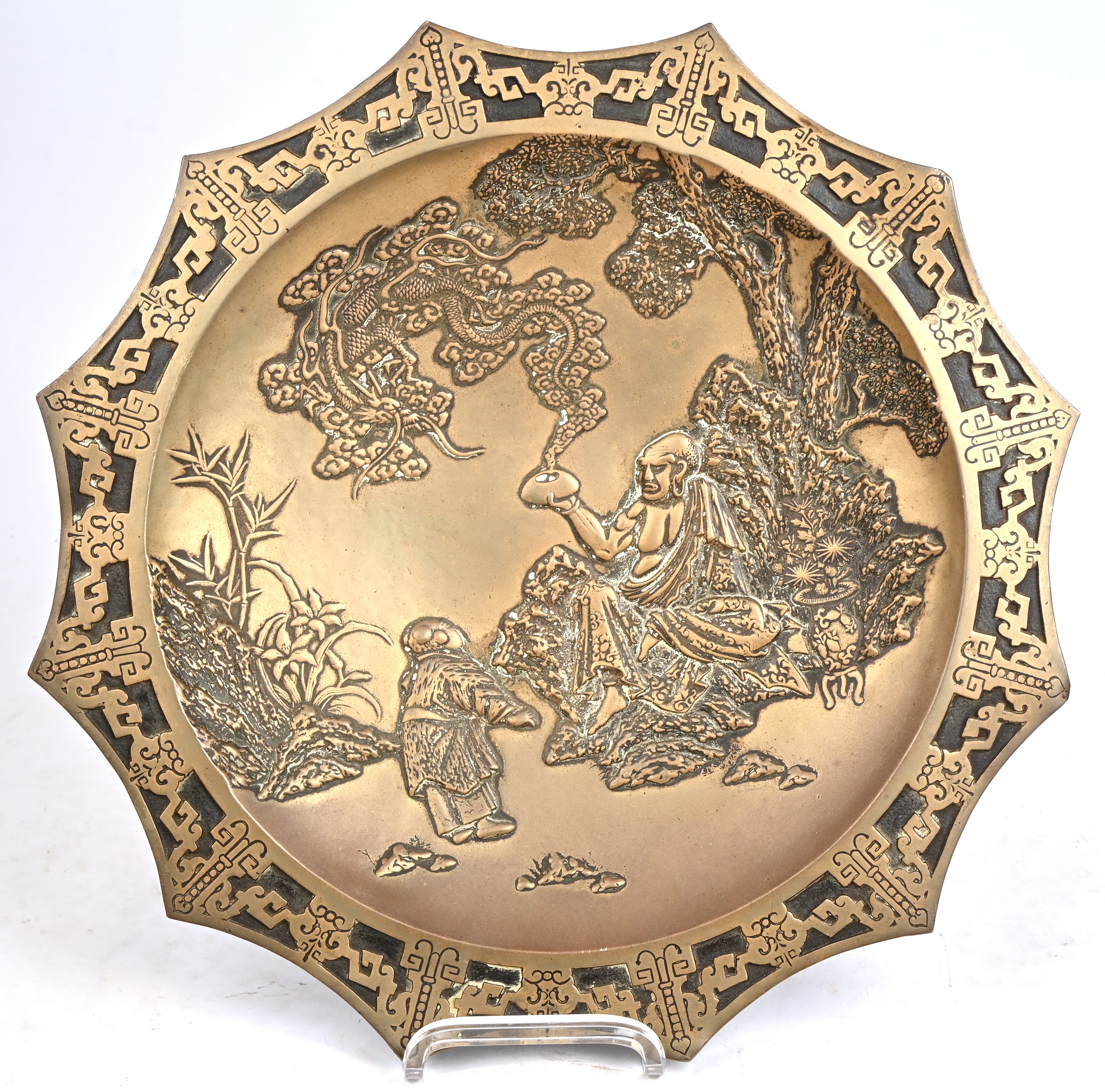 Een Japanse bronzen schotel met een draak en 2 figuren in een landschap Een Japanse bronzen schotel met een draak en 2 figuren in een landschap.
