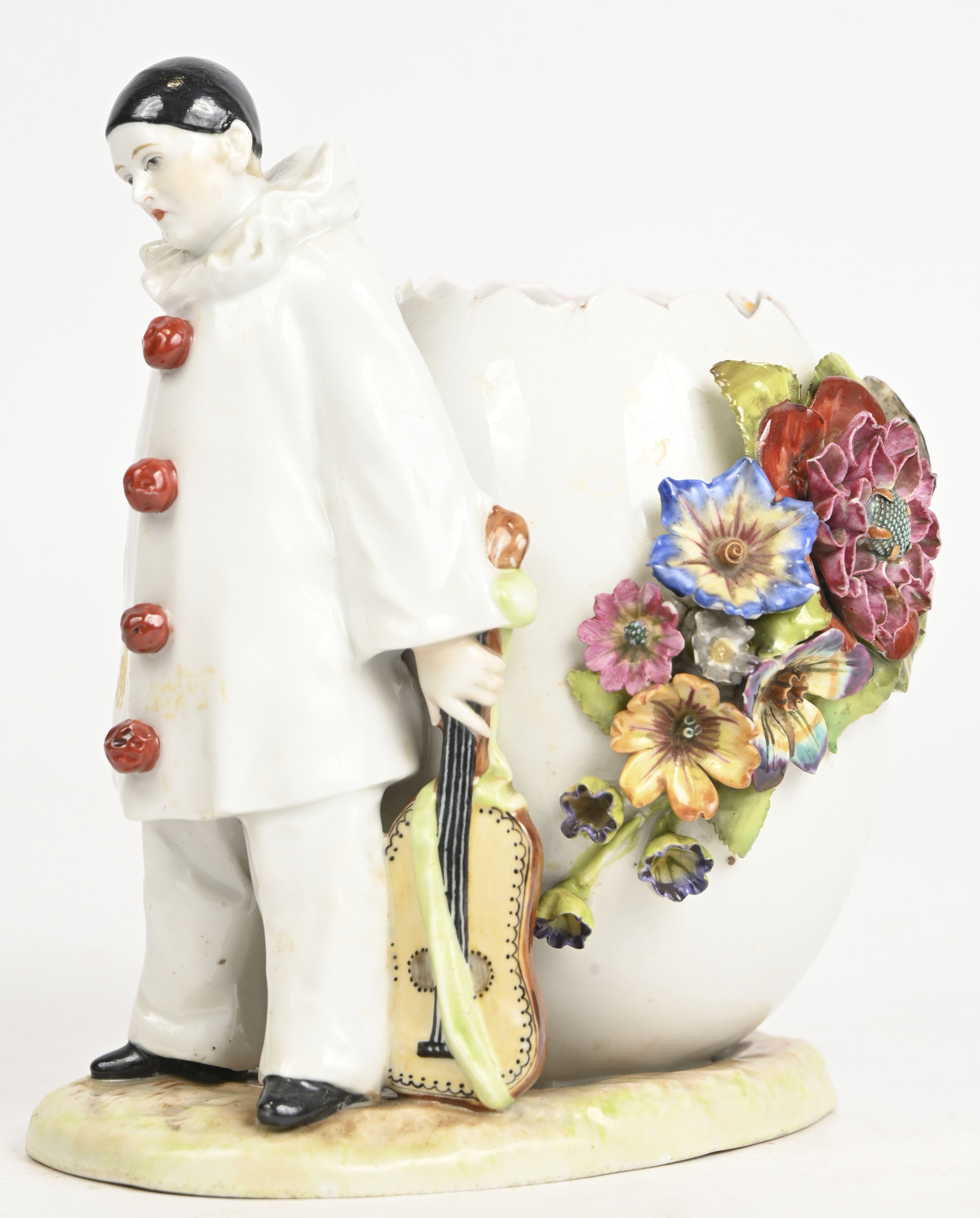 Een vaasje in de vorm van een open ei, geflankeerd door een Pierrot. Gemerkt Schierholz Een vaasje in de vorm van een open ei, geflankeerd door een Pierrot. Gemerkt Schierholz.
