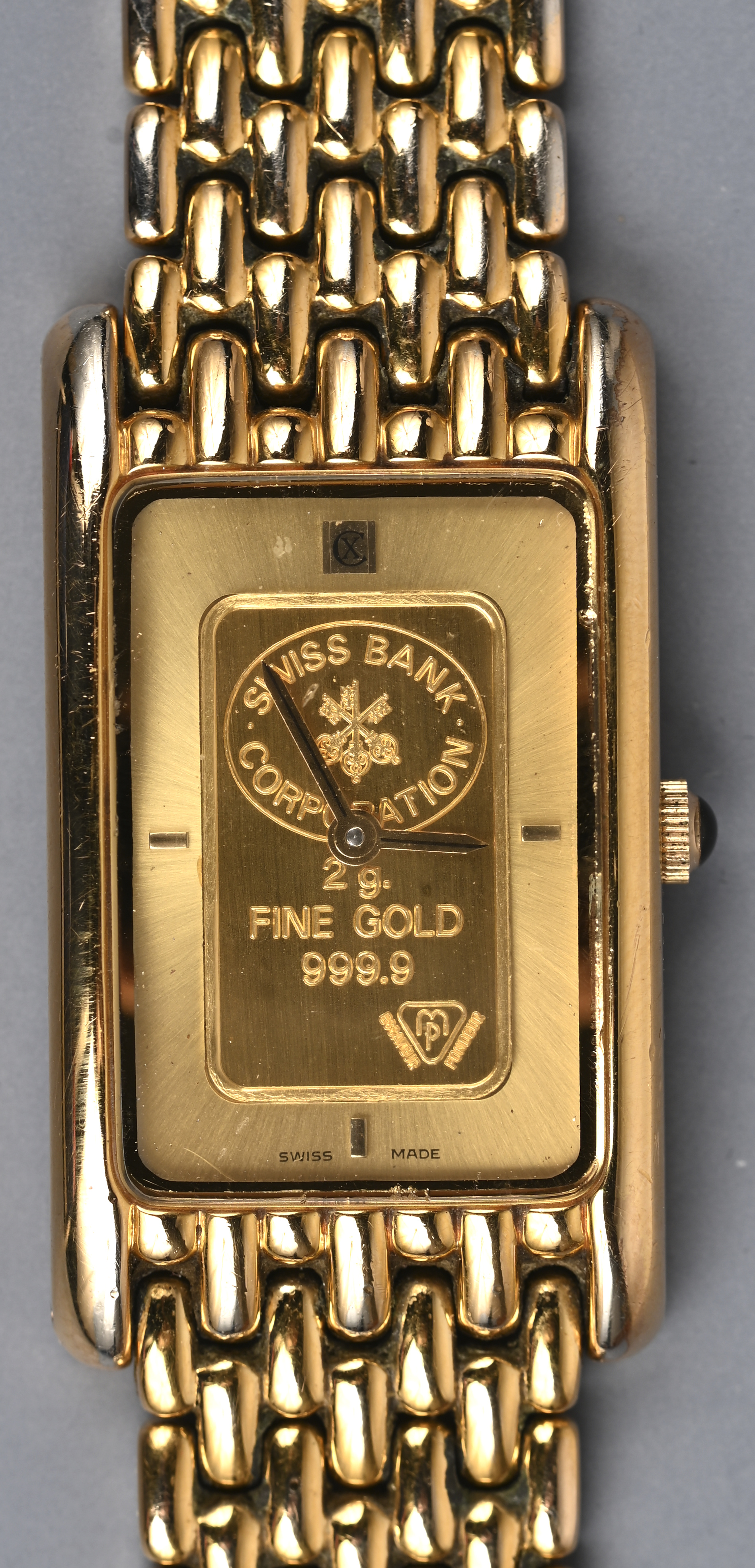 Een vergulde quartz polshorloge met goudstaaf van 2 gram, 999.9, uitgegeven door de bank van Zwitserland Een vergulde quartz polshorloge met goudstaaf van 2 gram, 999.9, uitgegeven door de bank van Zwitserland.